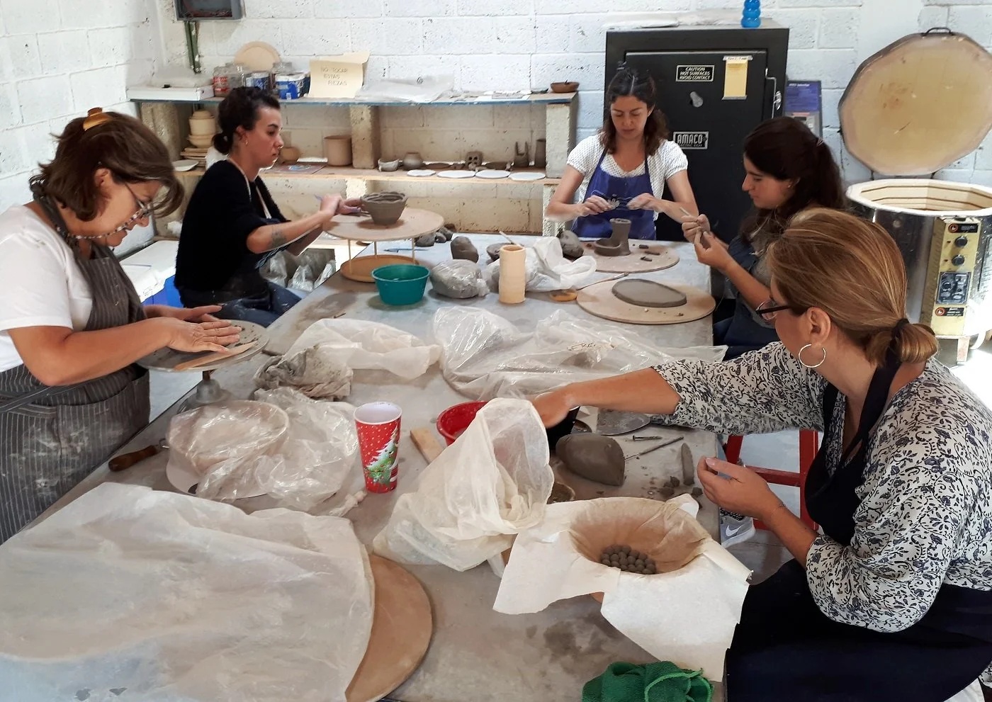 Grupo de alumnos creando piezas a mano durante una clase de cerámica en Gaspart Studio.