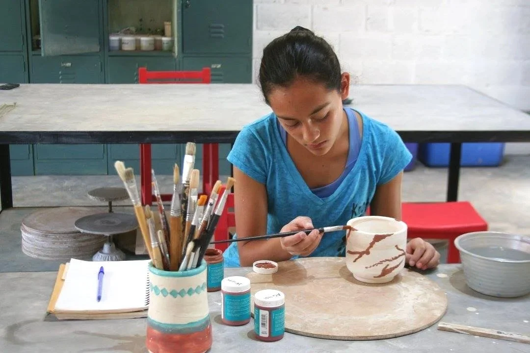 Alumna decorando una pieza durante una clase de cerámica en Gaspart Studio.