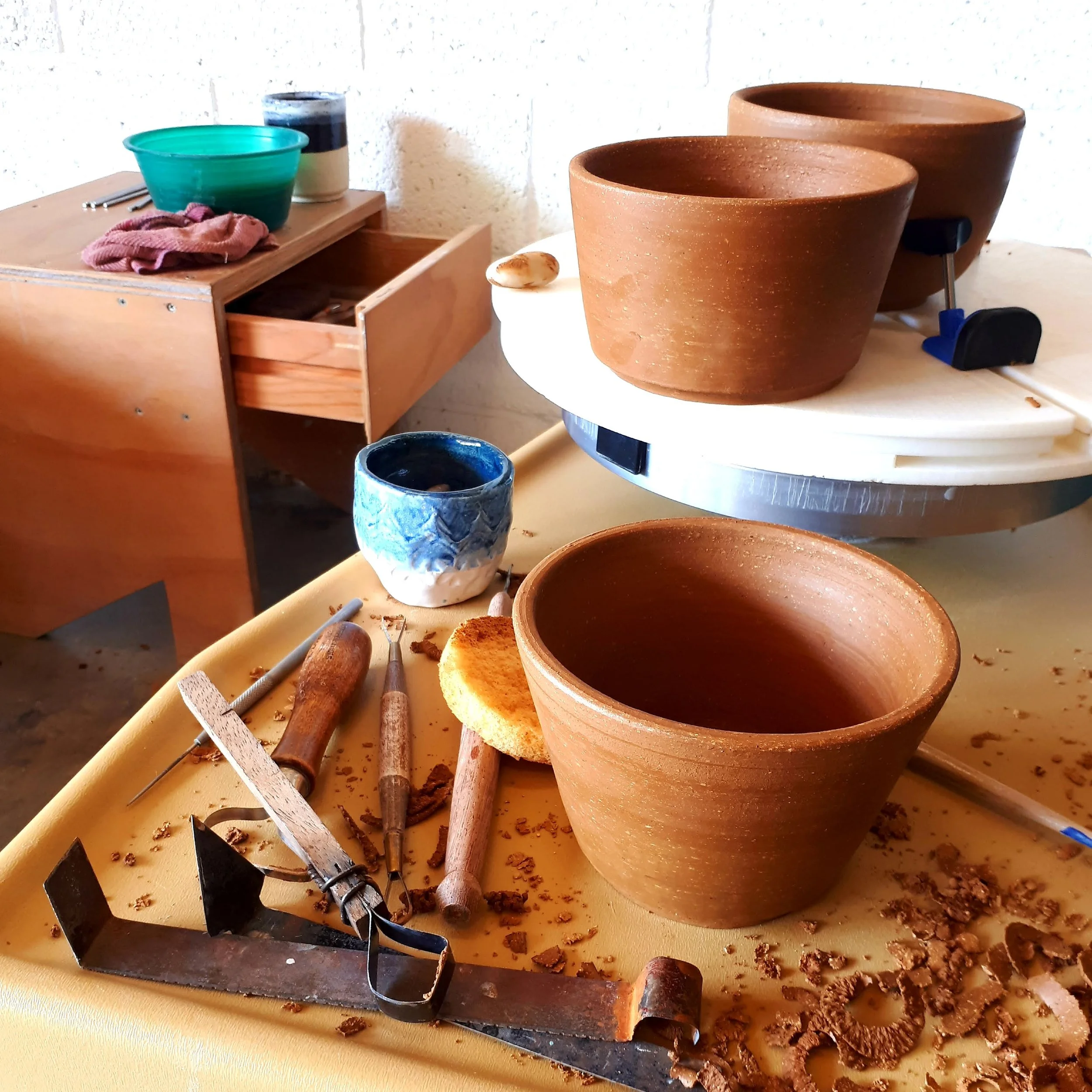 Piezas de cerámica en proceso sobre el torno durante un taller intensivo de torno de cerámica.