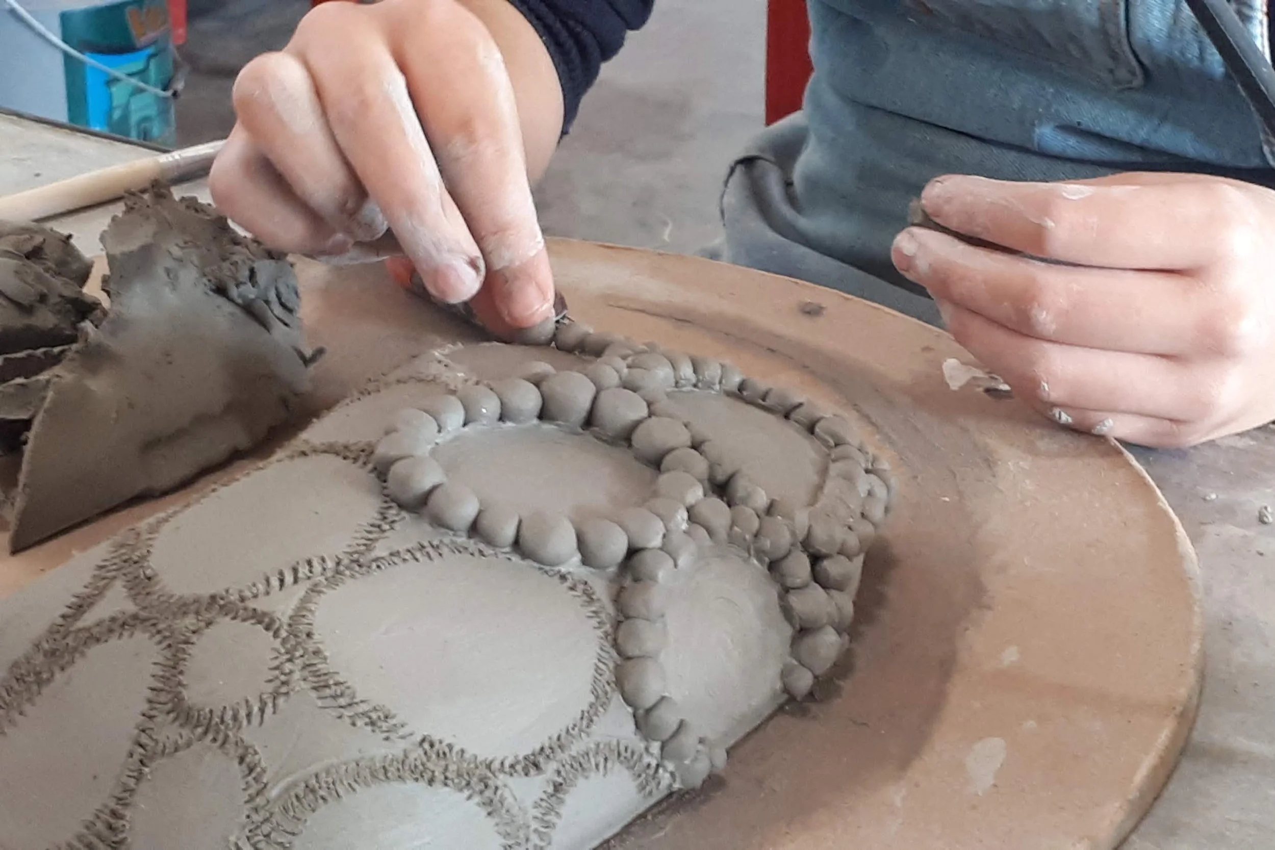 Proceso de construcción manual y modelado de una pieza de cerámica con detalles hechos en barro.