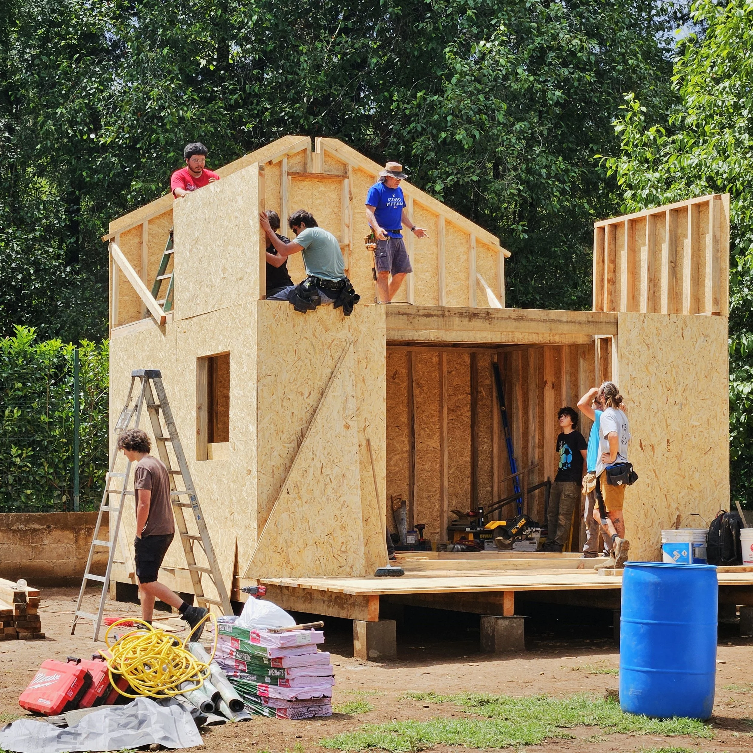 Estudiantes construyendo una estructura de madera estilo norteamericano durante un curso práctico de construcción en Gaspart Studio.