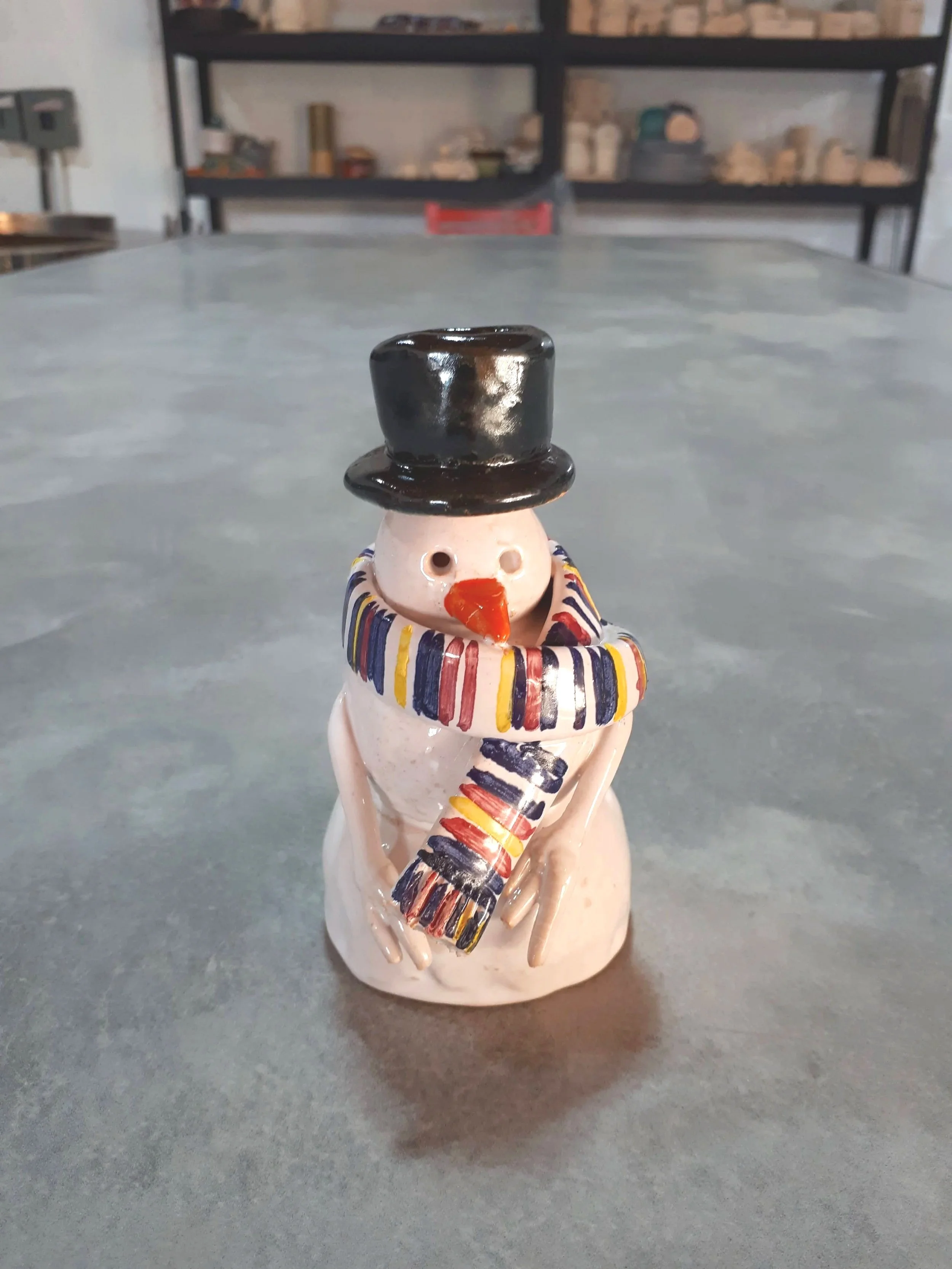 Muñeco de nieve de cerámica hecho a mano durante un taller de piezas navideñas.