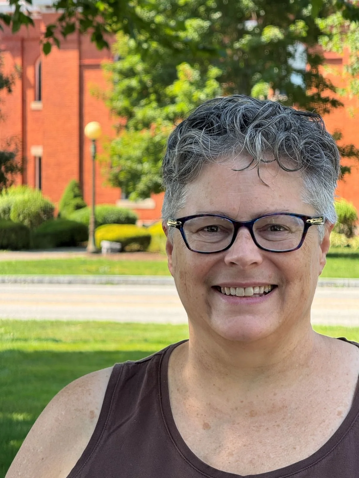 Michelle Doucette Cunningham, outdoors on a sunny day, in front of Tolland Town Hall.