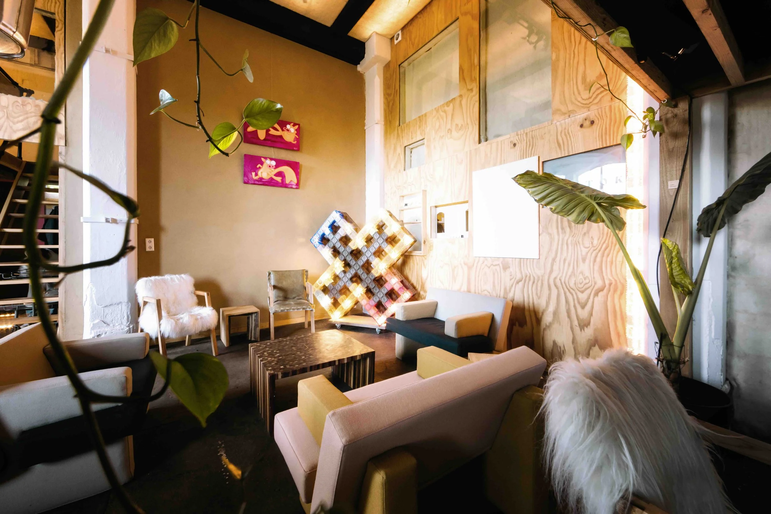 Een gezellige woonkamer met diverse stoelen, een houten wand en planten.