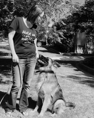 Wholistic Canine owner Terra looking happily at Ollie the German Shepherd who is looking at her for instruction during their private training session.