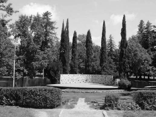 Black and white photo of the garden theater in William Land Park, Sacramento, with tall cypress trees and a pond