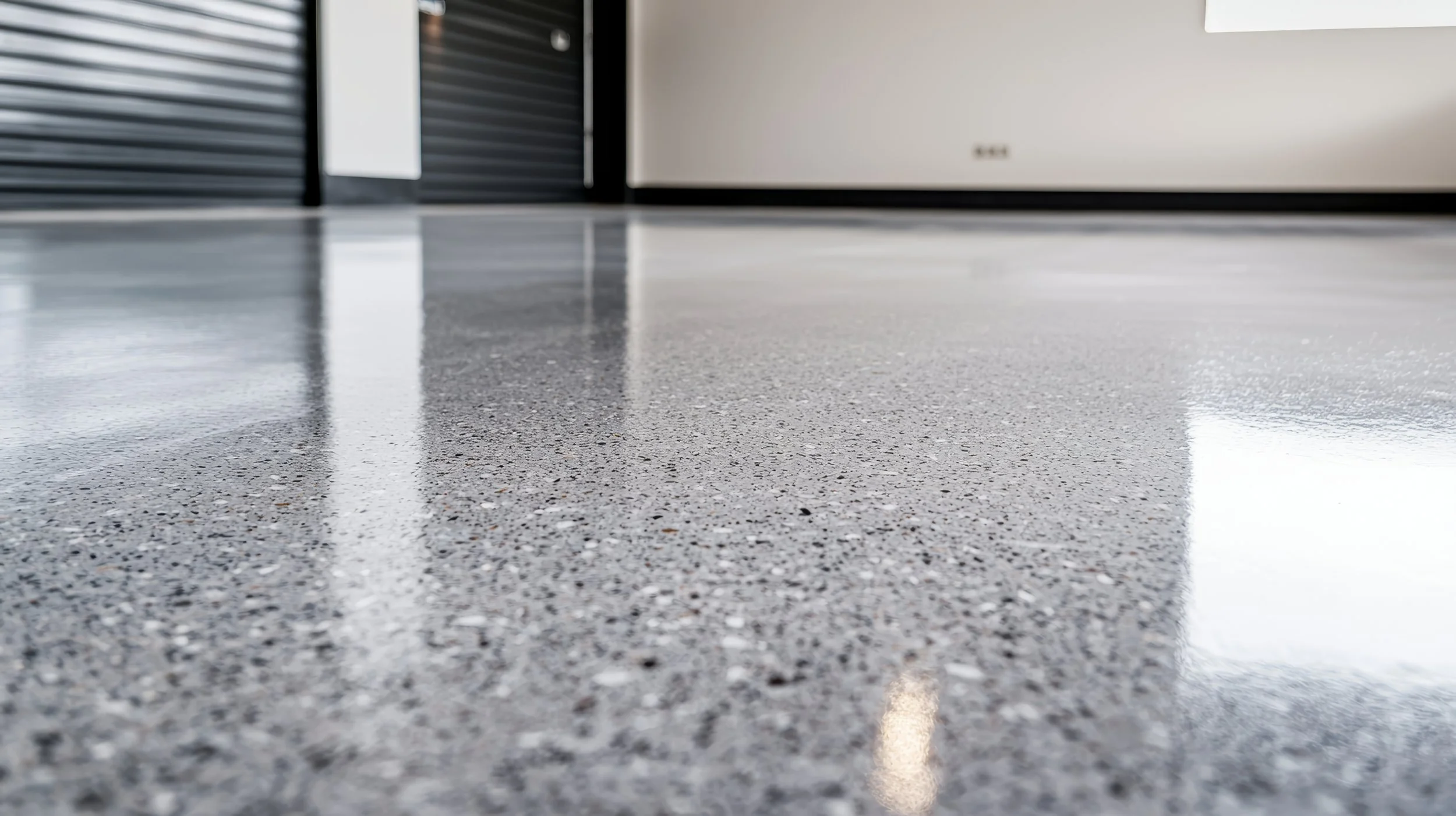 Close-up of a polished speckled granite floor with reflections of nearby objects.