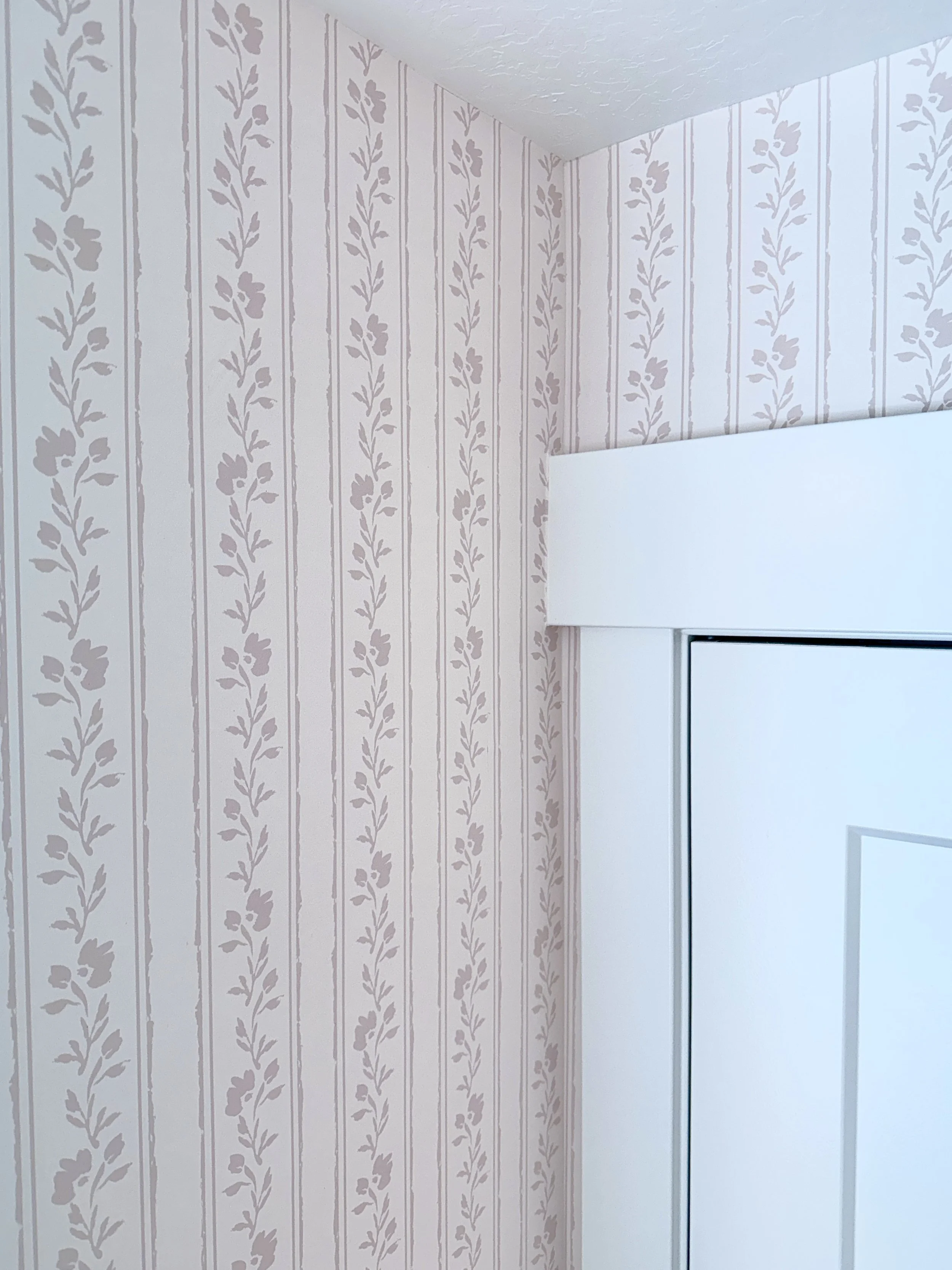 Soft blush pink floral striped wallpaper for baby girl nursery.