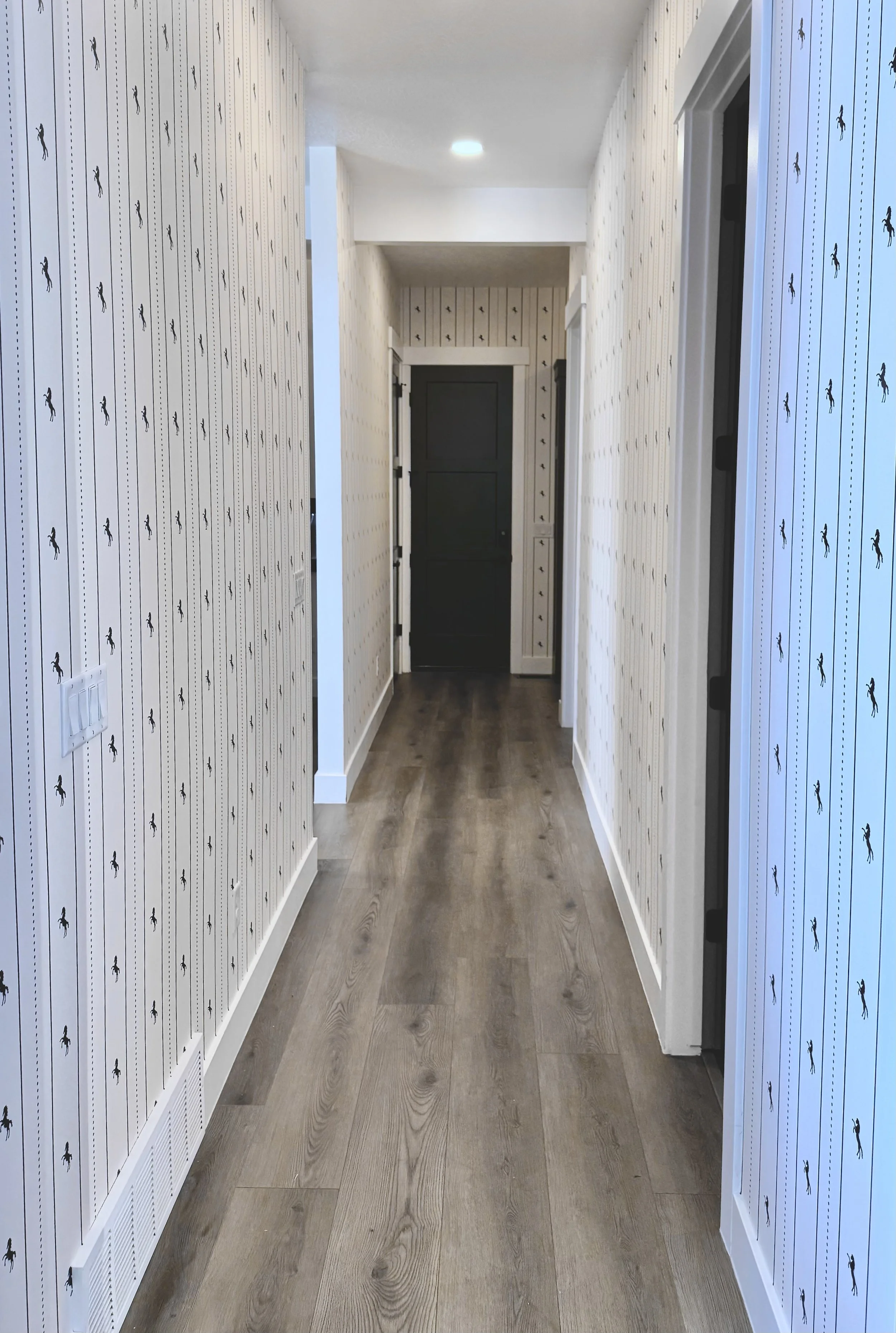 I'm Not Too Western Green Horse Wallpaper by The Torrie Jarrett Line Wall Blush wallpaper installation in a hallway with black interior doors