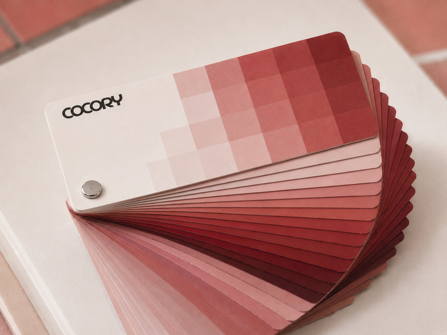 Color palette fan deck on a white surface, showing various shades of red and pink from light to dark, with the brand name 'COCORY' in the top left corner.