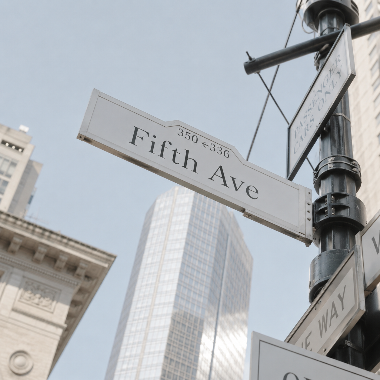 Street sign for Fifth Avenue in New York City, with tall modern buildings and historic architecture surrounding it.
