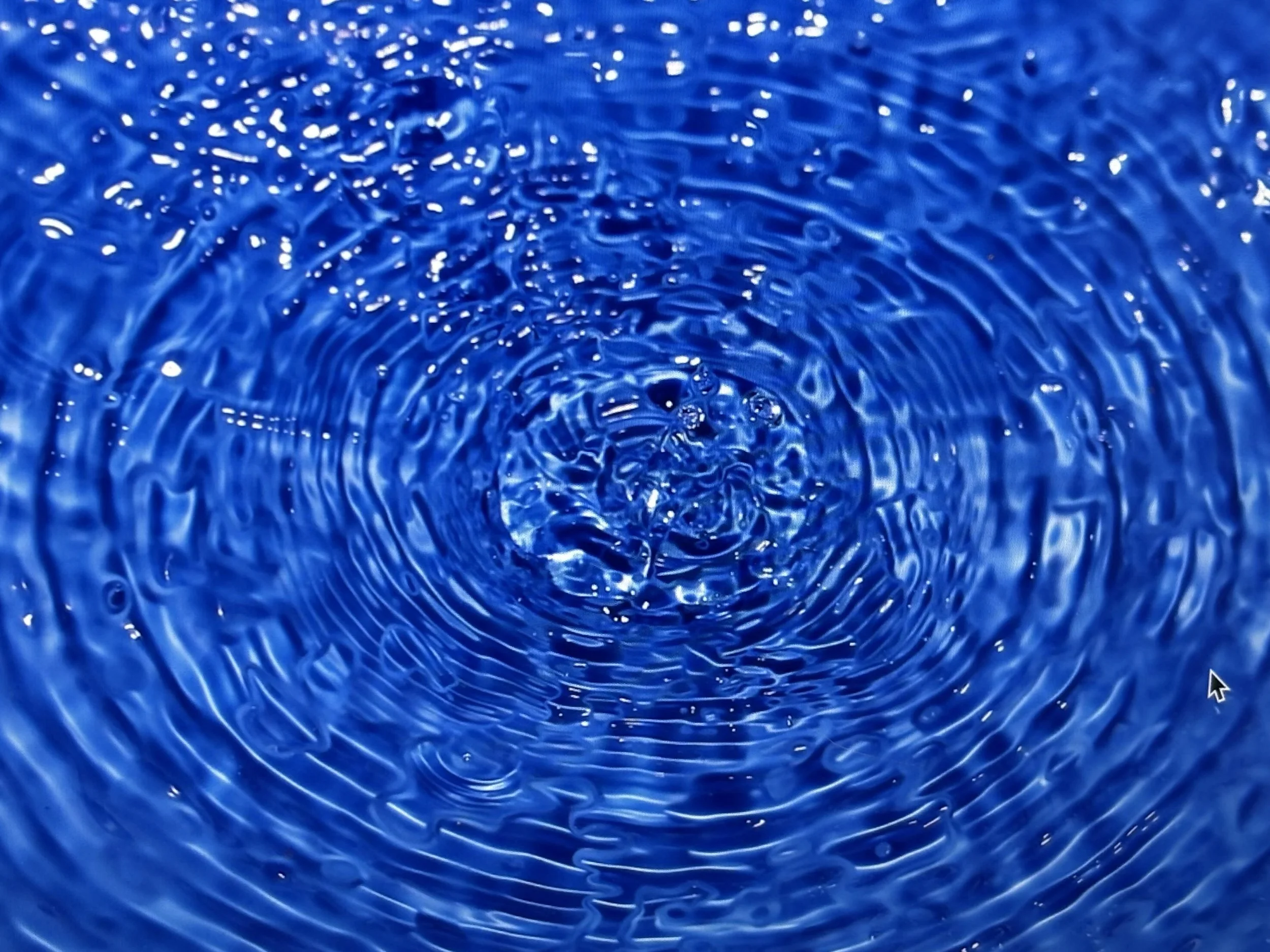 Close-up of rippling water on a blue surface.