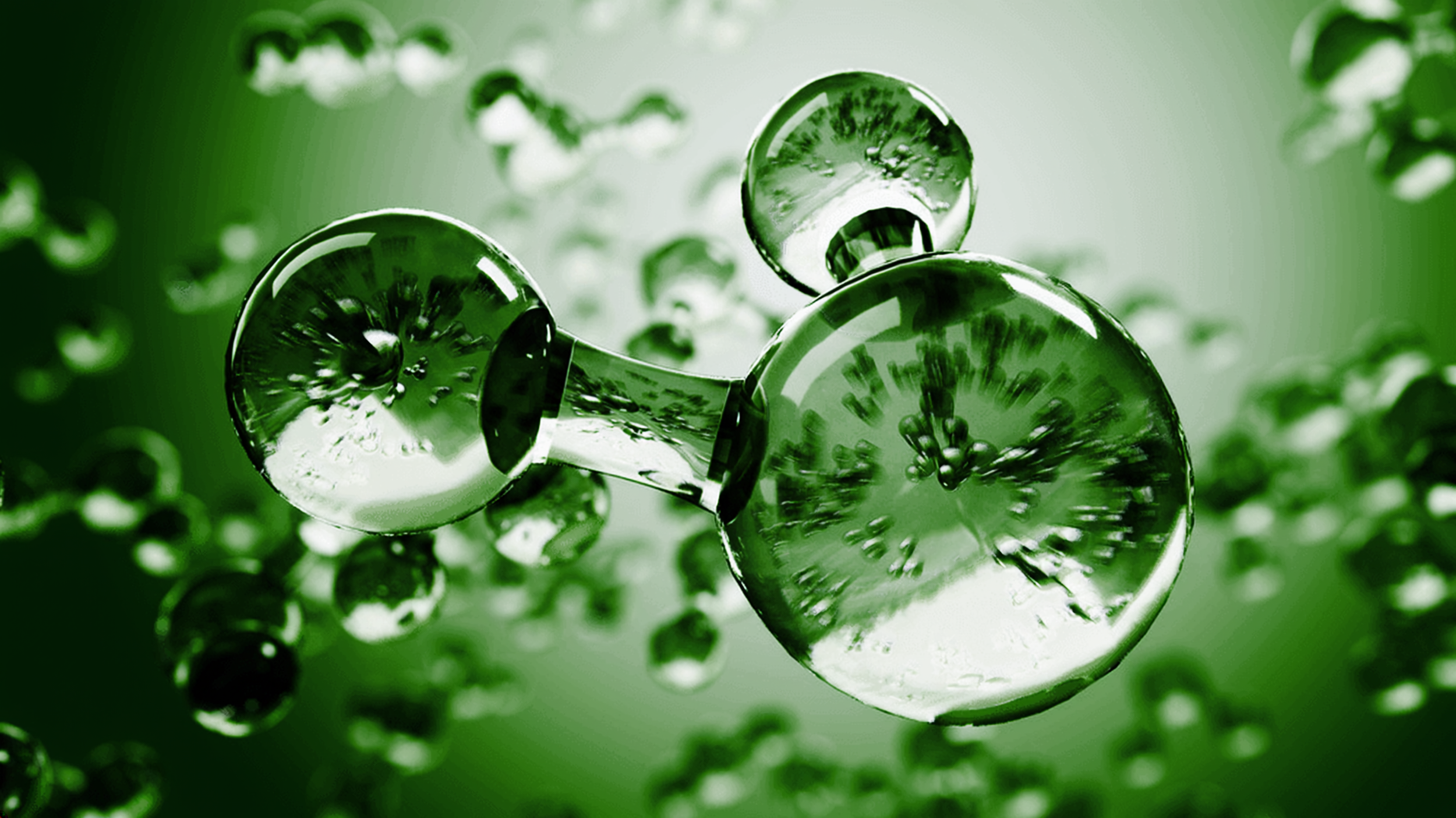 Close-up of green and clear water balloons or orbs with reflection and bubbles inside, against a blurred green background.
