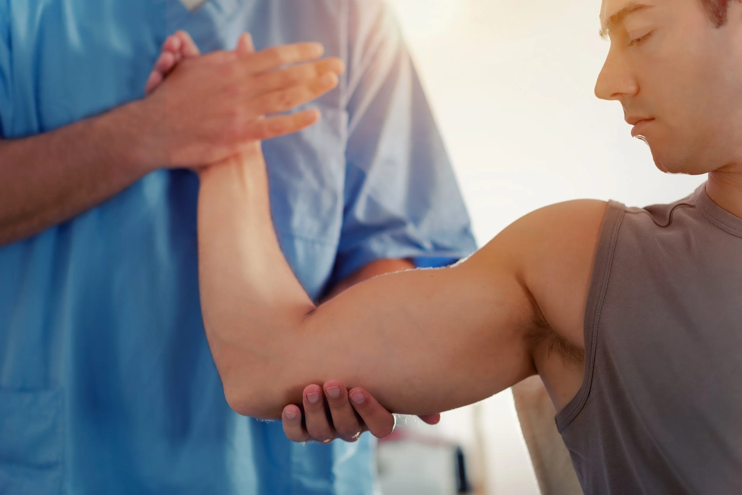 Person receiving a vaccination or injection in their upper arm from medical professional.