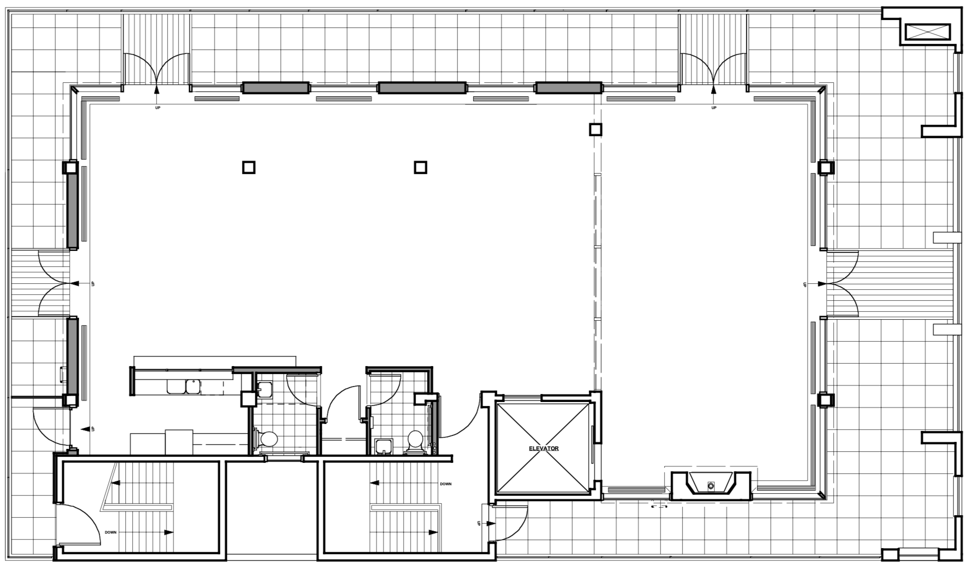 Floor plan of a building with multiple rooms, including restrooms, an elevator, and staircases.