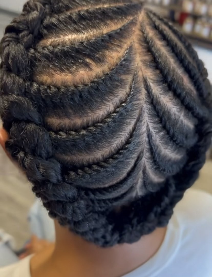 Close-up of a person's head with freshly styled braided hair in a pattern of curved rows.
