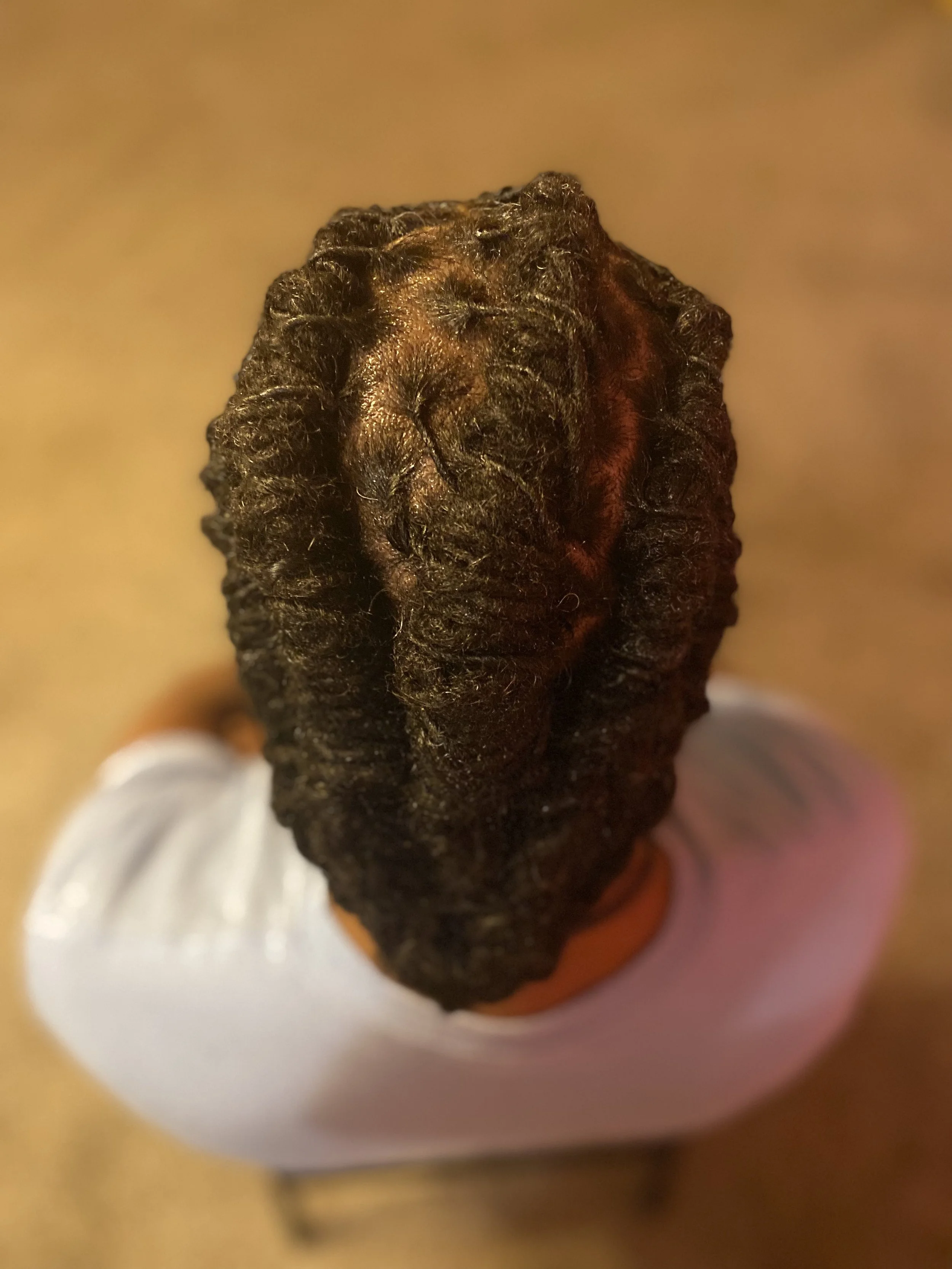 Close-up of a dark, wrinkled object, possibly a roasted or dried pepper, held in a white cup.