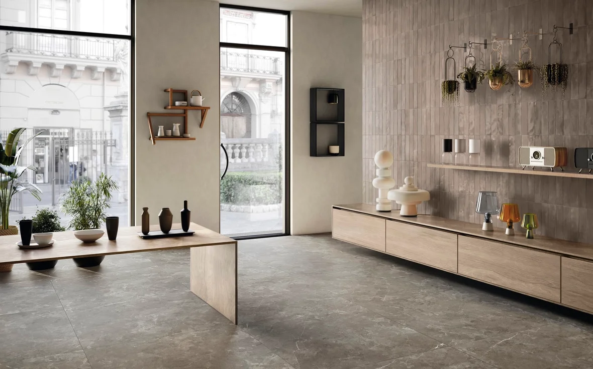 Modern interior space featuring Iris Ceramica porcelain stoneware tiles from the Elementi collection, showcasing the Pietra di Sciara finish on floors and textured vertical wall tiles, available through PietraCasa.