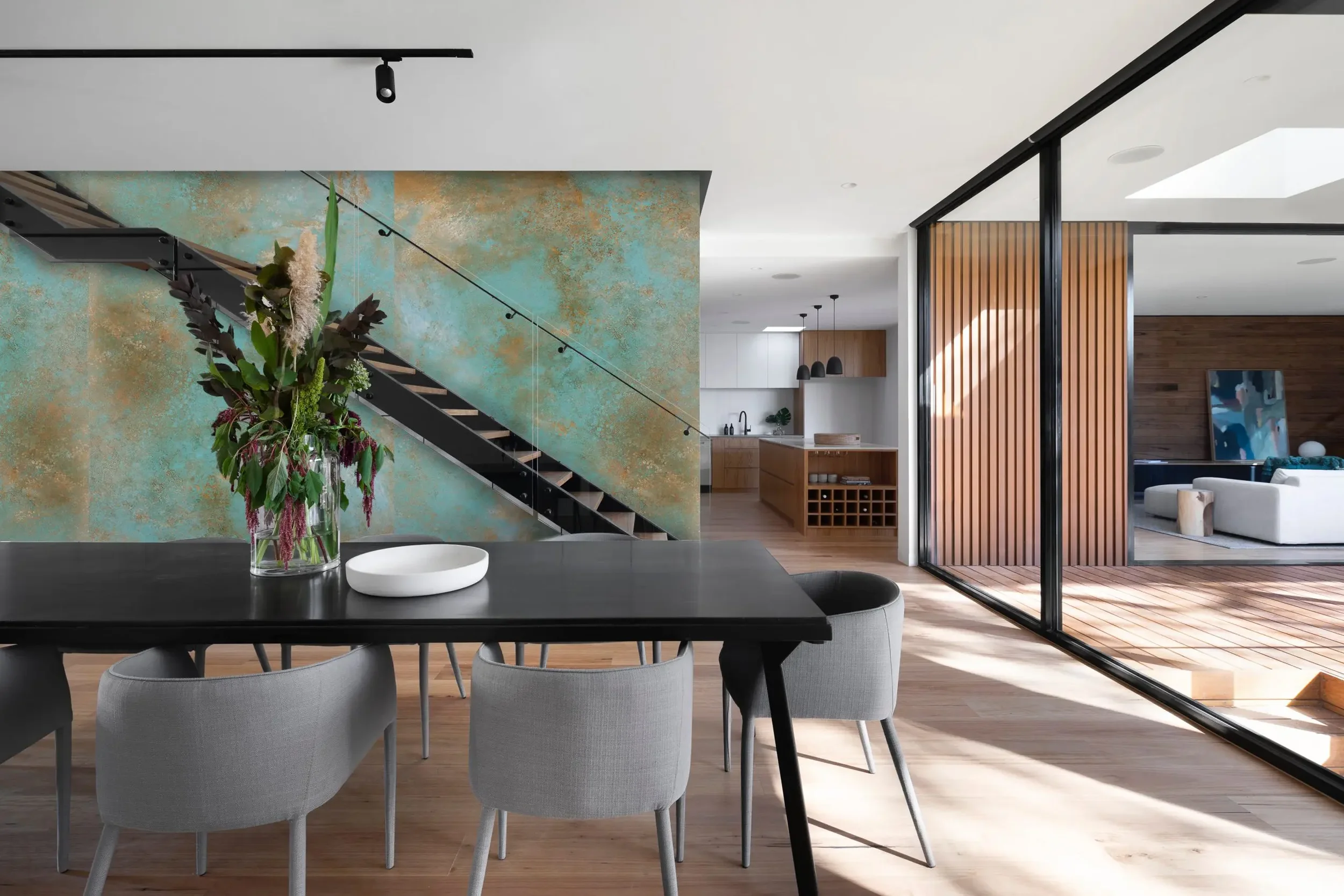 An accent wall featuring Laminam Ossido Verderame porcelain slabs, which replicate the oxidized, verdigris look of aged copper, available through PietraCasa.