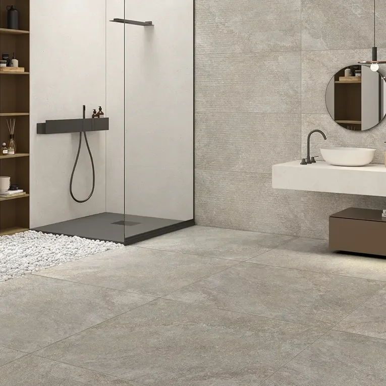 Modern bathroom interior showcasing the Arkè Grey stone-effect porcelain tile collection by Ceramiche Keope, featuring large-format flooring and textured wall tiles, available through PietraCasa.
