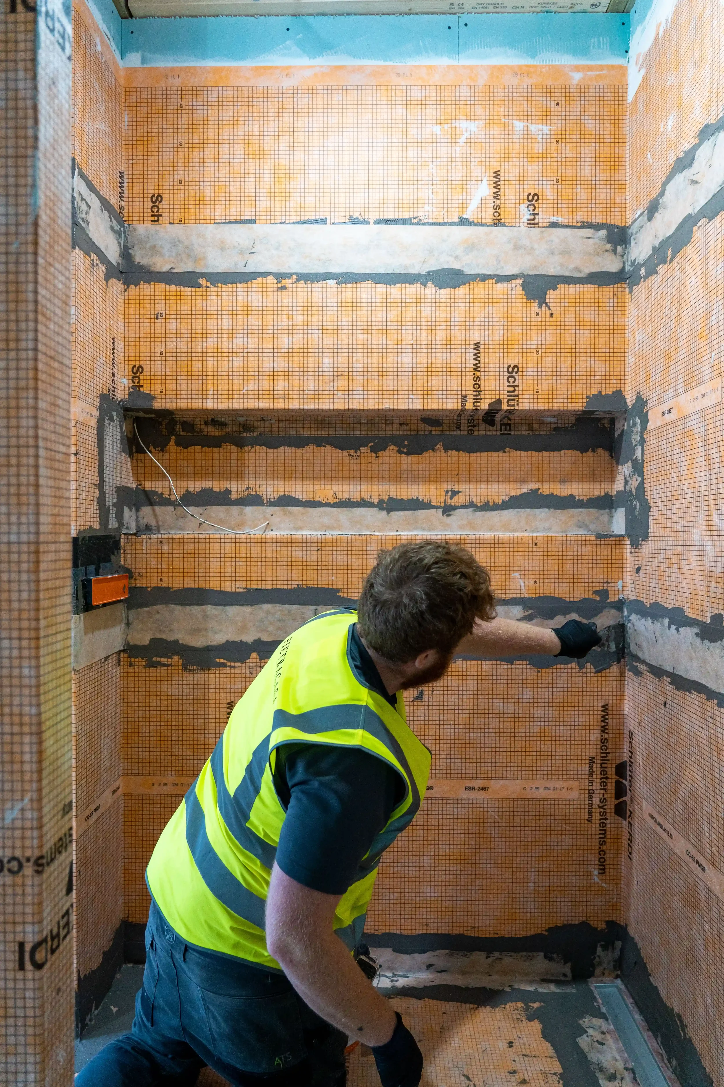 Installation of a Schluter waterproofing system in a custom shower enclosure.