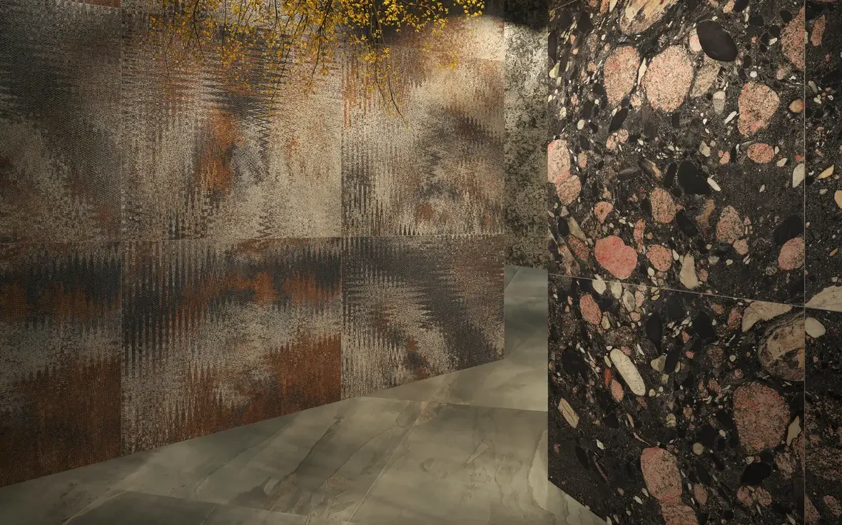 Interior installation featuring large-format porcelain slabs from the Iris Ceramica THÉKĒ collection, showcasing a rust-toned oxidized metal wave effect on the left wall, a textured 'Ceppo' stone motif on the right, and polished grey floor tiles, ava