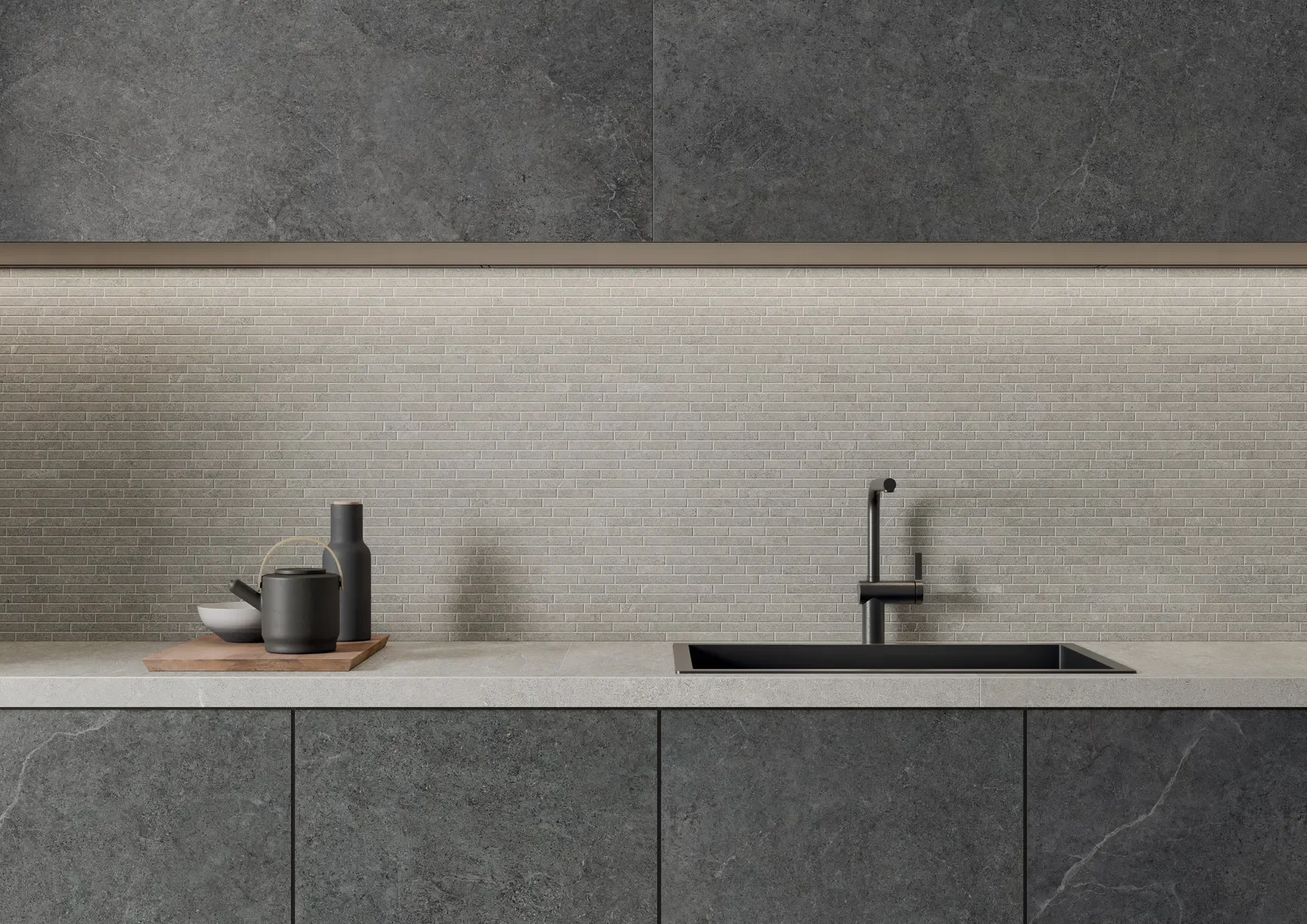 Modern minimalist kitchen design utilizing dark Limestone di Impronta stone-effect tiles on large-format cabinet doors, contrasted with a neutral linear-mosaic backsplash, expertly supplied by PietraCasa.