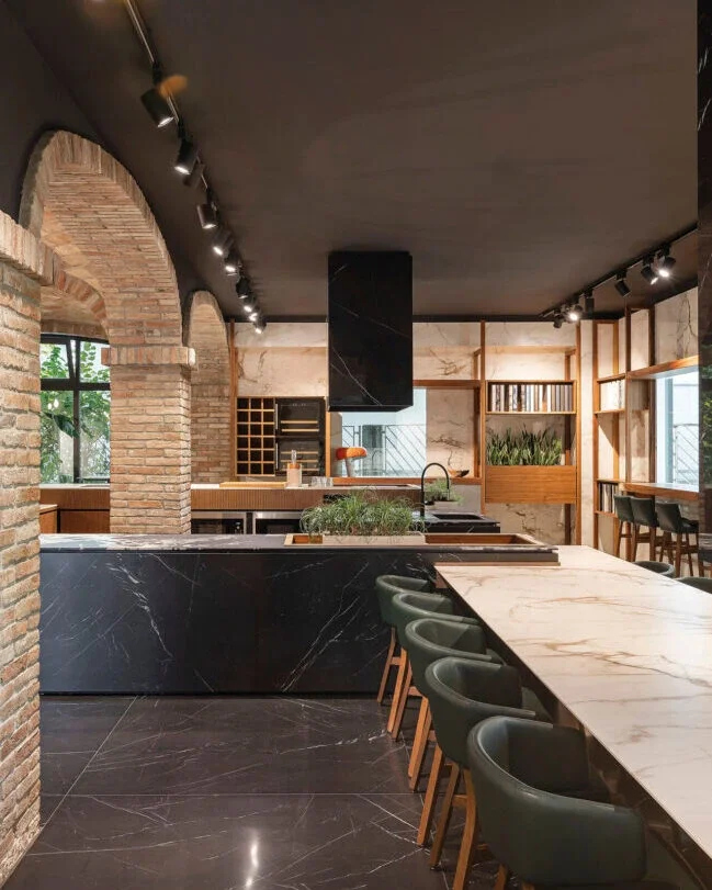 Modern industrial-style kitchen featuring a large island clad in premium Ariostea dark marble-effect ceramic slabs, supplied and installed nationwide by PietraCasa.