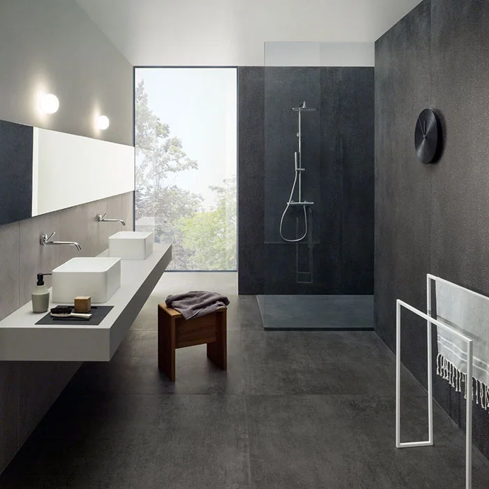A modern bathroom featuring Lea Ceramiche's Slimtech Concreto collection, designed by Fabio Novembre, characterized by large-format, ultrathin laminated porcelain stoneware, available through PietraCasa.