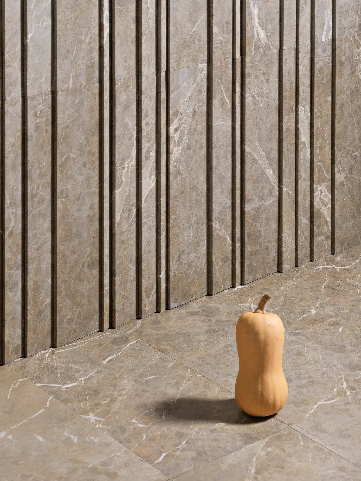 High-end Luce di Carrara architectural natural stone surface collection featuring 3D dimensional wall panels paired with matching stone flooring, available through PietraCasa.
