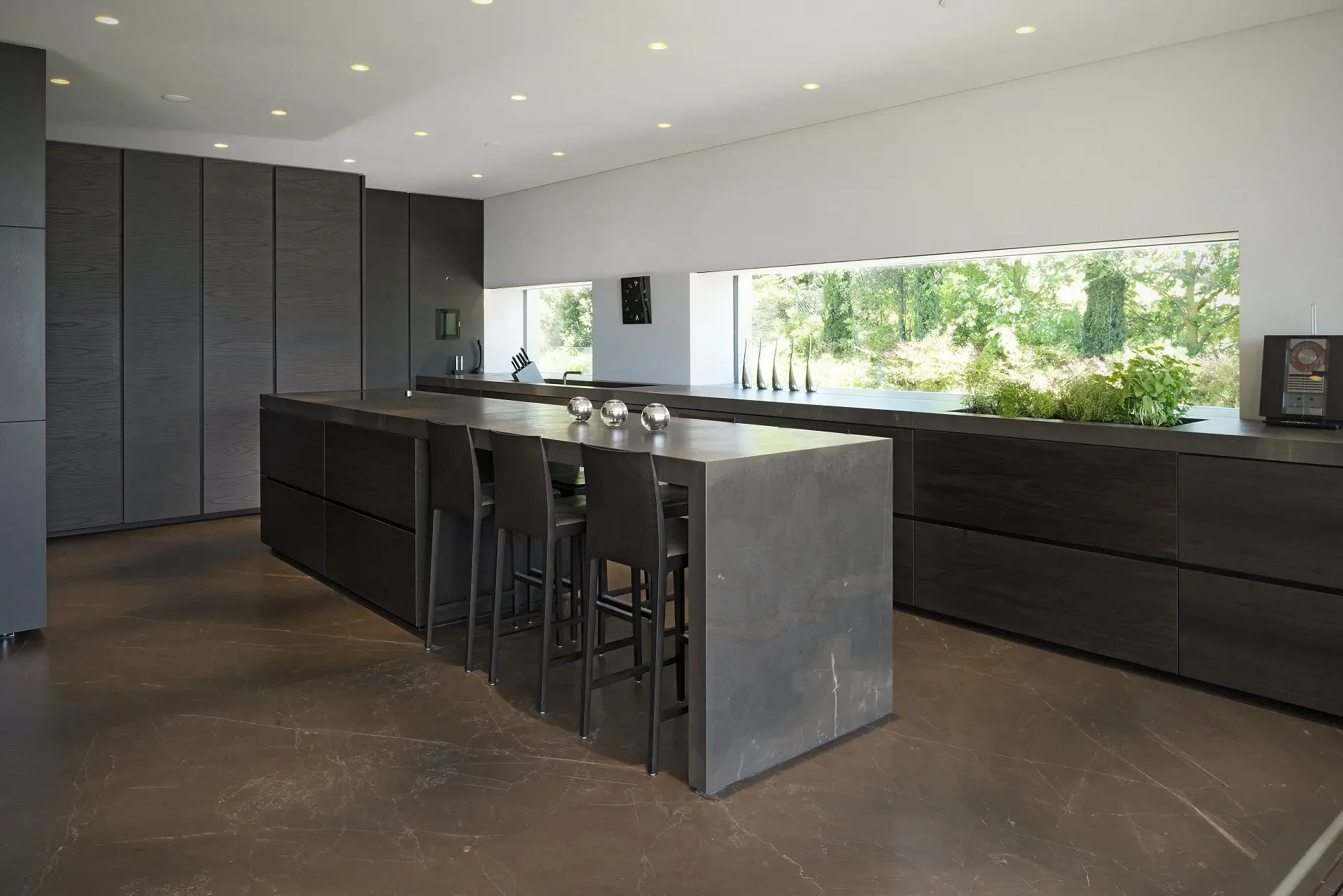 Luxurious, minimalist kitchen featuring premium natural stone surfaces from Antolini, supplied by PietraCasa.