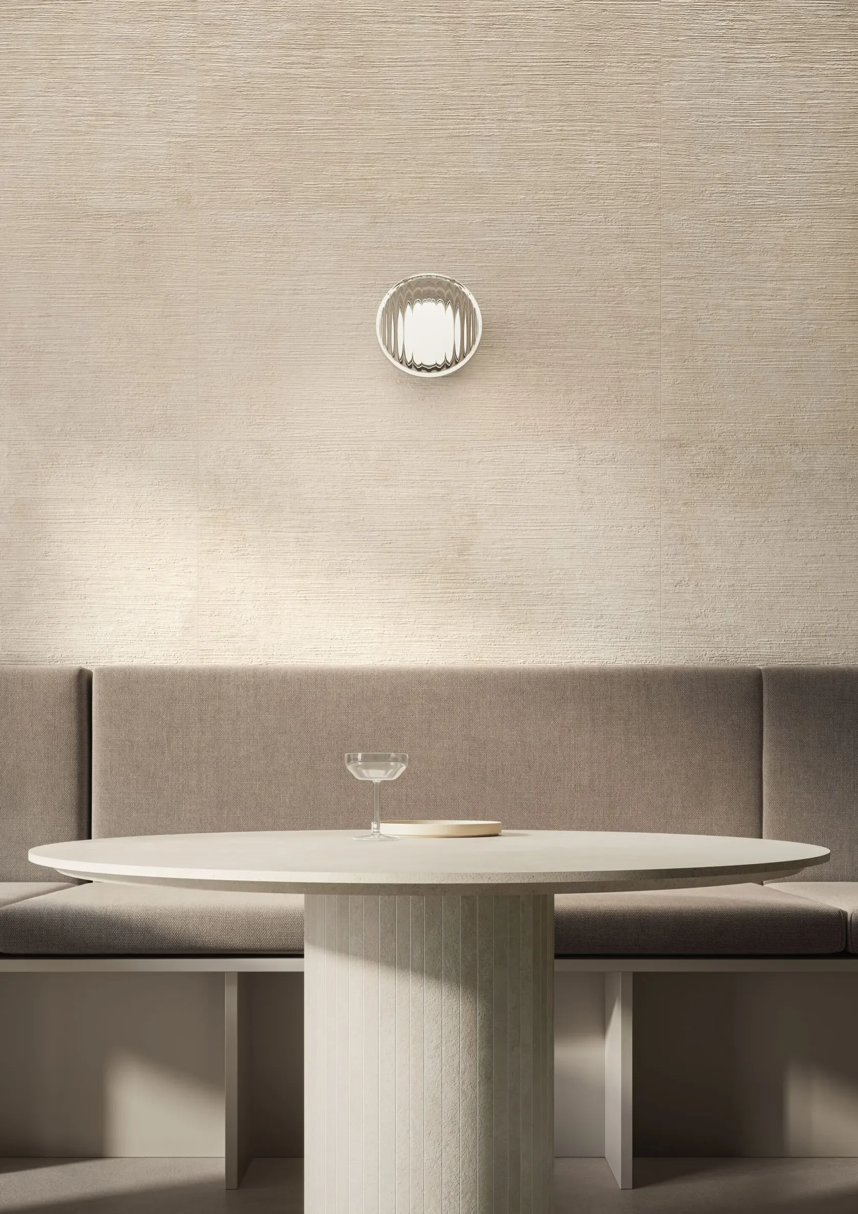 Warm minimalist interior featuring the Impronta Italgraniti I Travertini porcelain tile collection, showcasing architectural wall panels and a fluted dining column table with realistic travertine vein-cut effects, supplied by PietraCasa.