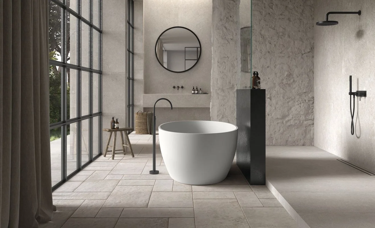 Luxurious modern bathroom interior featuring a minimalist freestanding tub and large-format tile flooring, expertly supplied by PietraCasa.