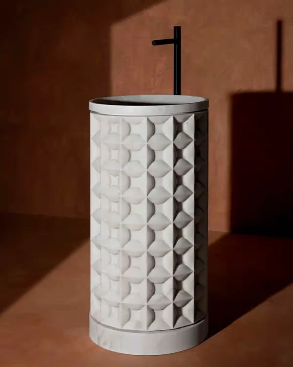 The Dawn freestanding washbasin by Kreoo, designed by Christophe Pillet, sculpted from a single cylindrical block of marble with an intricate hand-chiselled three-dimensional geometric texture, available through PietraCasa.