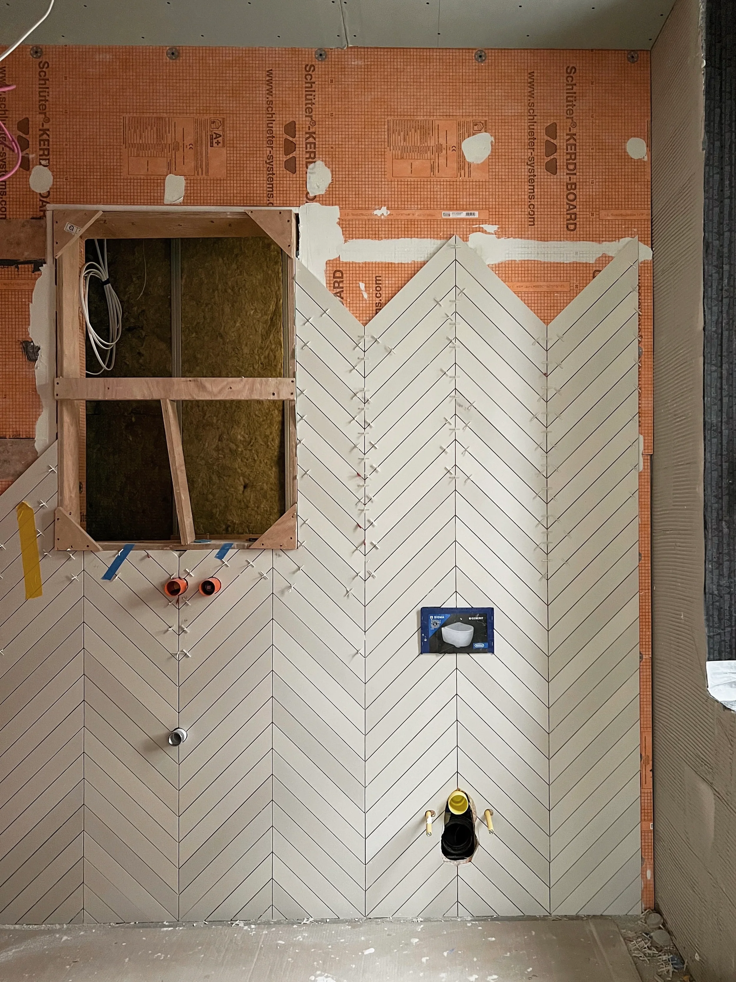 Installation of Mutina Mews chevron tiles over a Schluter-KERDI waterproofing system.