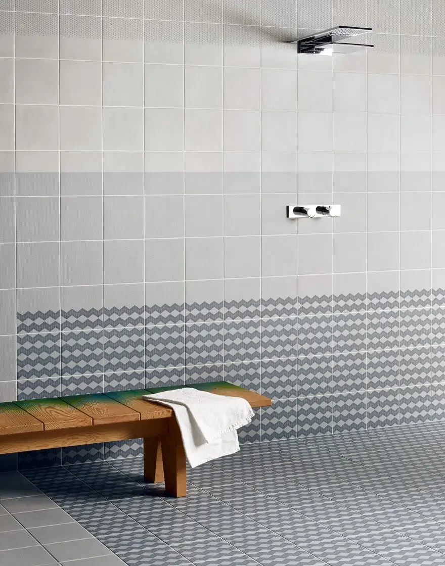 Bathroom interior featuring the Mutina Tape ceramic tile collection in gray, specifically the Cobble and Half patterns, characterized by the illusion of decorative tape, available through PietraCasa.