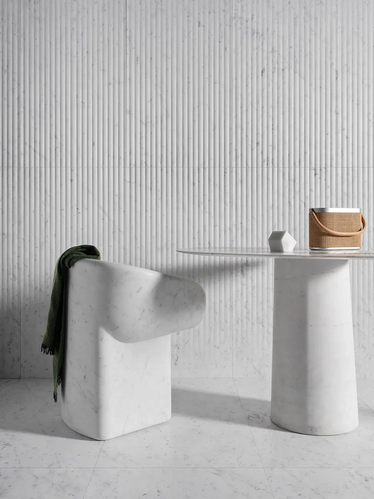 A sculptural swivel dining chair from the Cosimo collection and a pedestal table from the Quilt collection by Luce di Carrara, both carved from premium Bianco Carrara marble, available through PietraCasa.