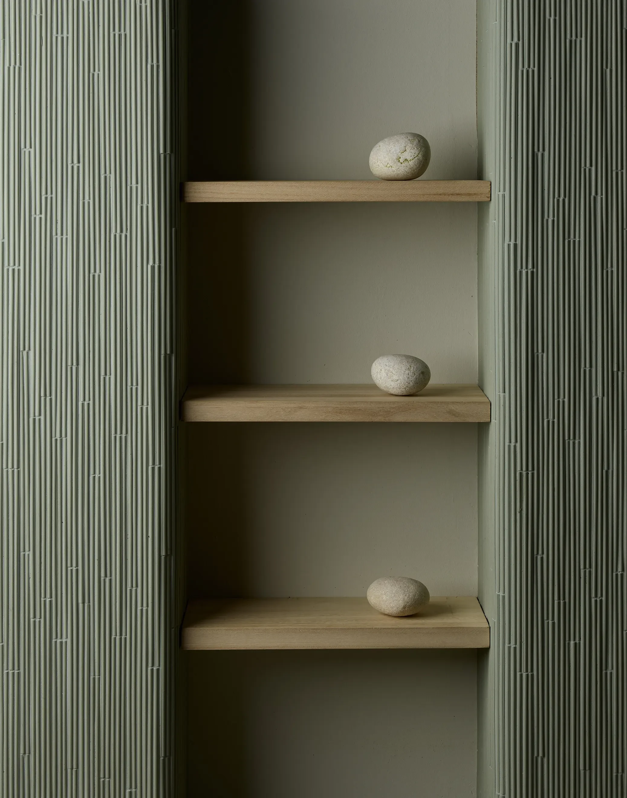 Fluted green wall panels from the Phenomenon collection by Tokujin Yoshioka for Mutina, flanking shelving, available through PietraCasa.