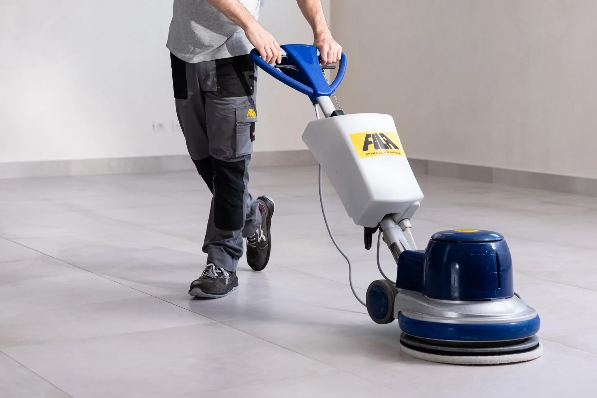 Professional rotary floor machine by Fila Surface Care Solutions in use on a clean tiled floor, supplied by PietraCasa.