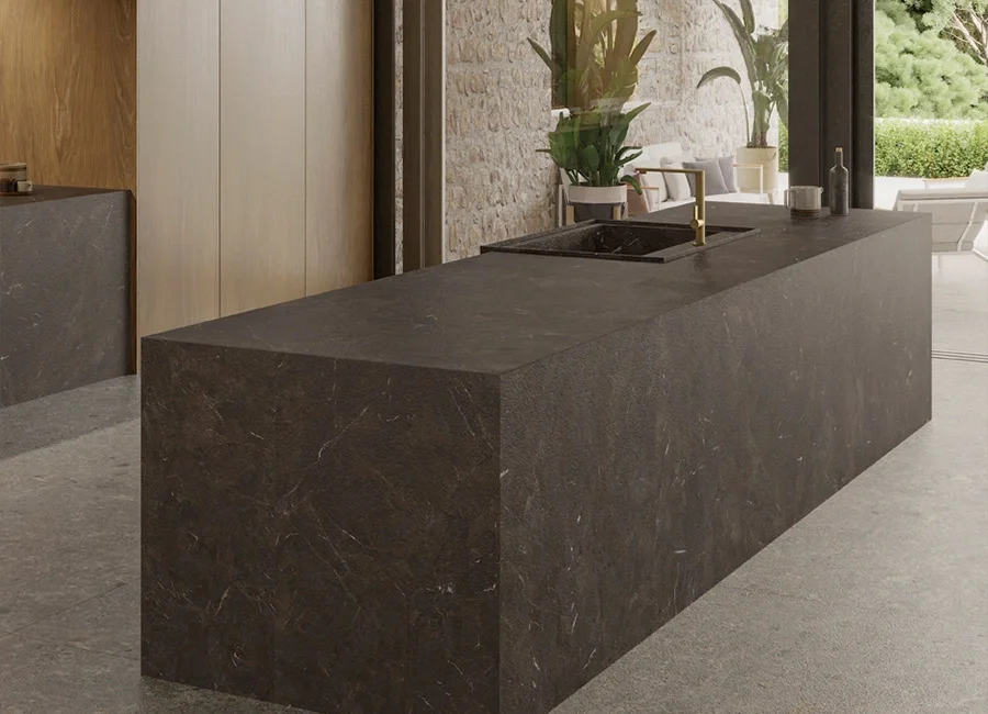 Sleek, dark kitchen island featuring the Inalco Umbra MDi porcelain surface in Marrón, characterized by subtle veining and an integrated induction cooktop, exclusively distributed in the UK by PietraCasa.