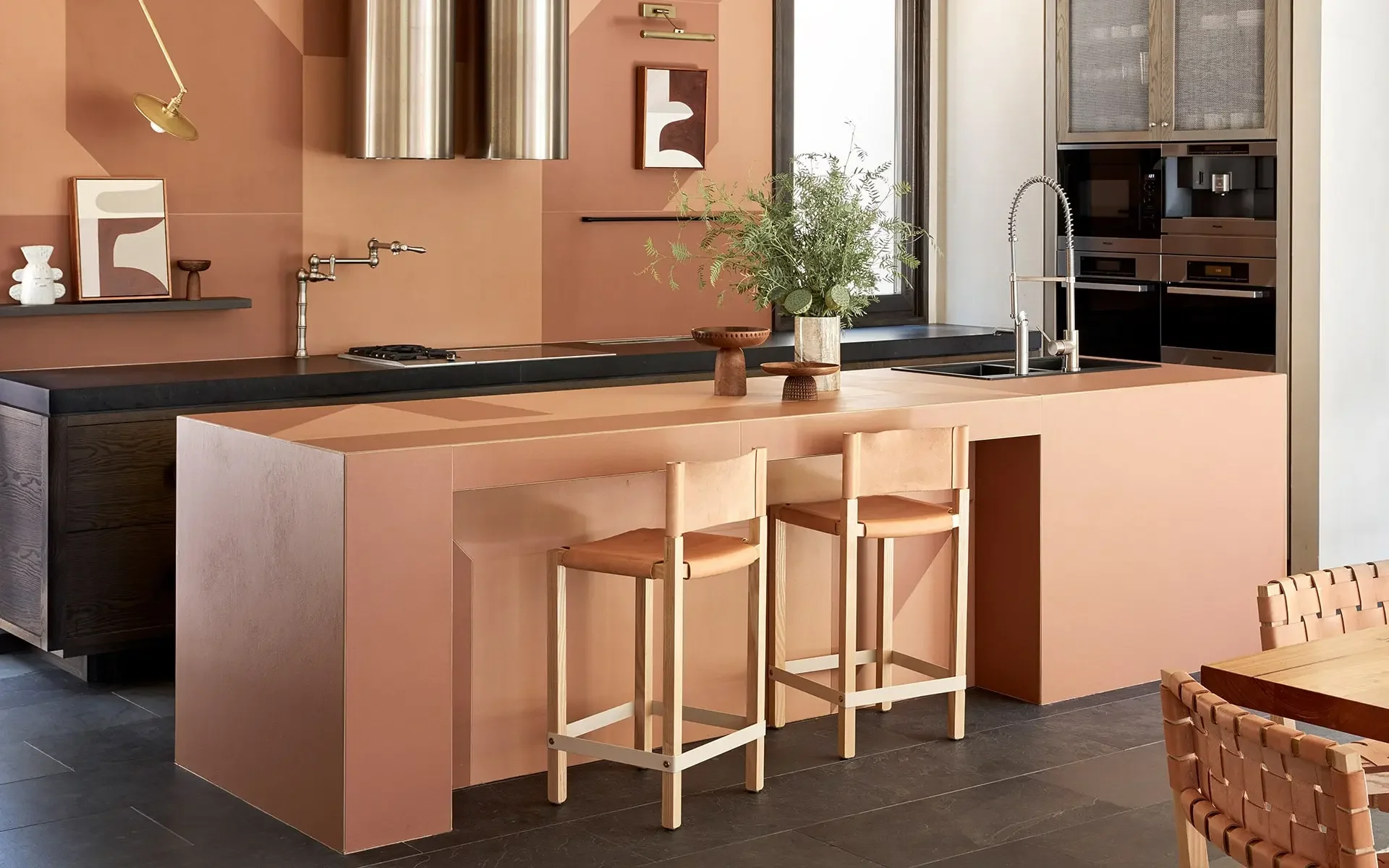 Modern kitchen interior featuring the Mattonelle Margherita collection by Mutina, showcasing warm terracotta tones on both the island and wall elements, available through PietraCasa.