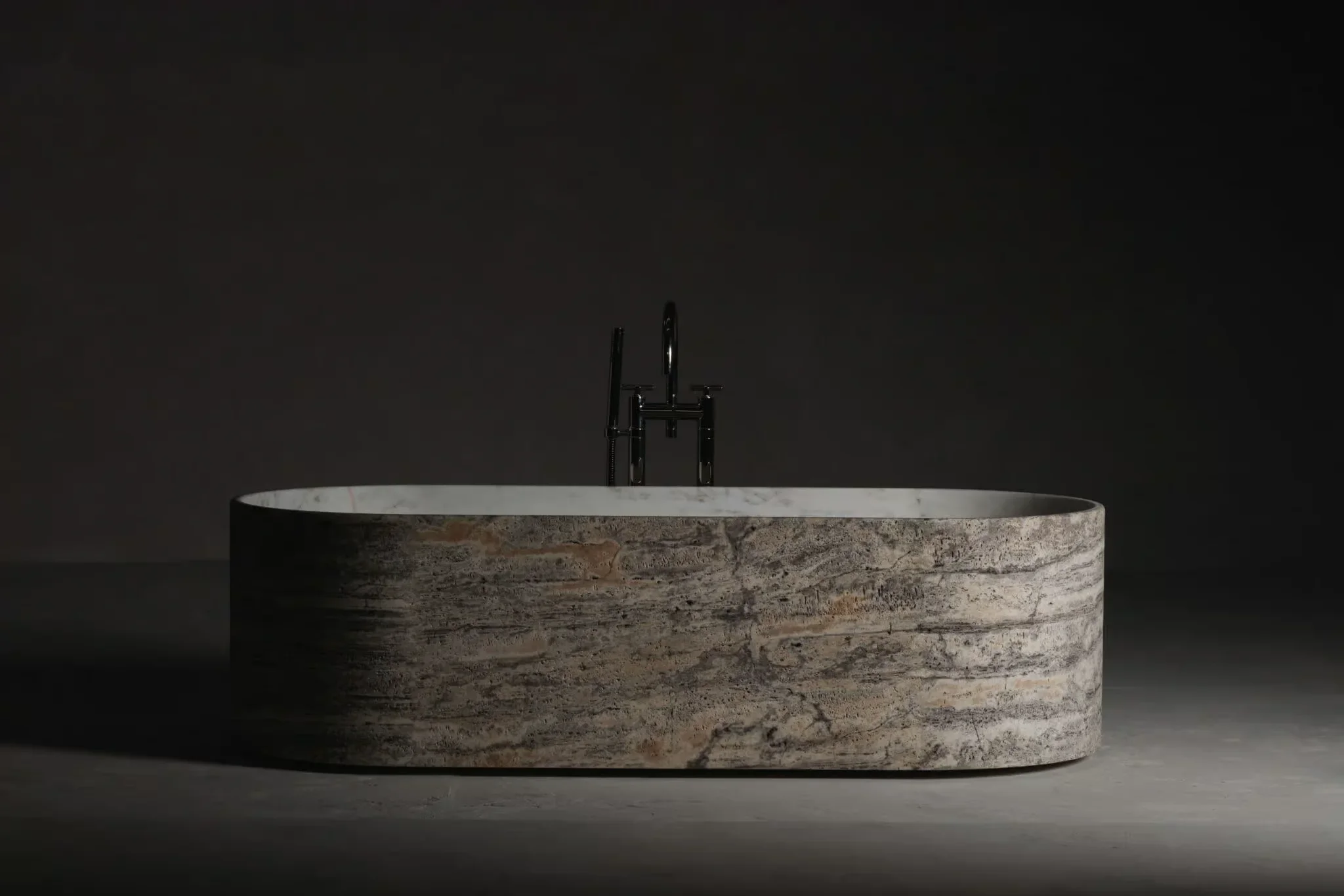The Blessed Tub Circle freestanding bathtub by the Italian brand Kreoo, designed by Christophe Pillet, featuring a sculpted natural stone exterior, available through PietraCasa.
