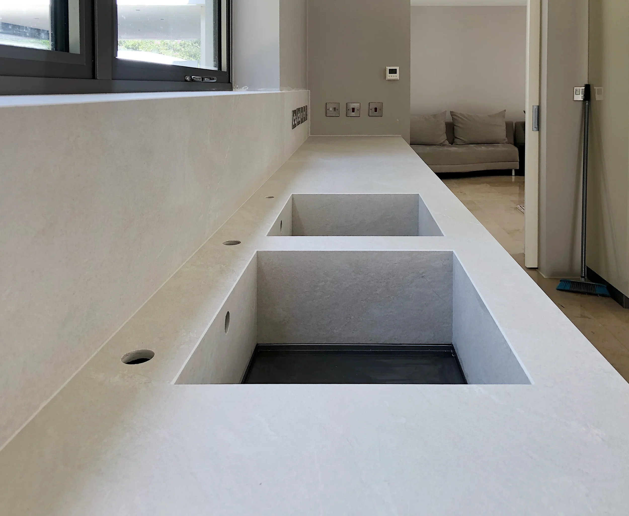 A precision-engineered beige stone-look porcelain worktop by PietraCasa featuring a matching integrated double sink with mitred edges and pre-drilled tap holes.
