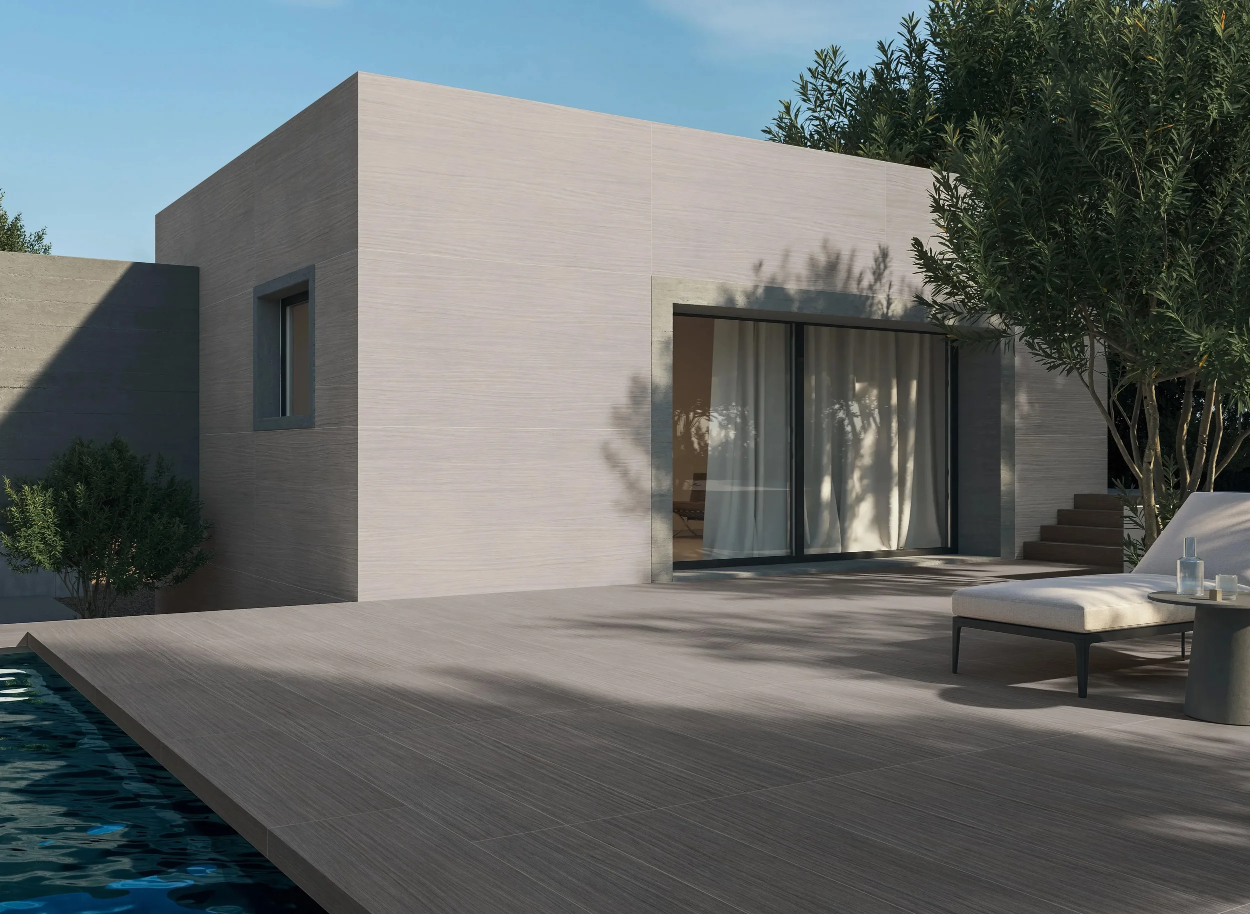 Modern outdoor pool setting featuring durable Florim Nature Mood porcelain stoneware tiles, expertly supplied and installed by PietraCasa.