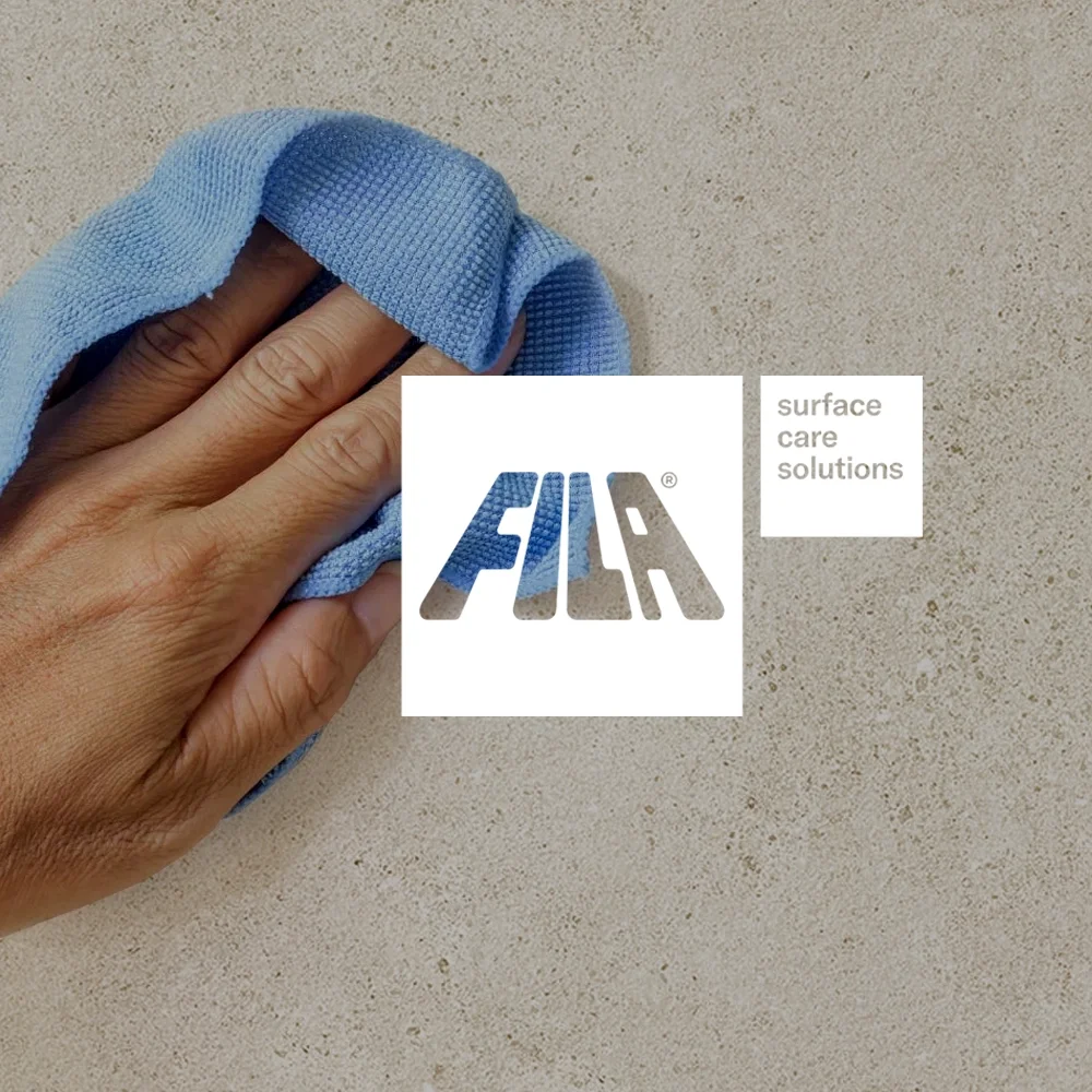Cleaning a porcelain surface with a blue cloth using FILA surface care solutions for post-installation tile maintenance.