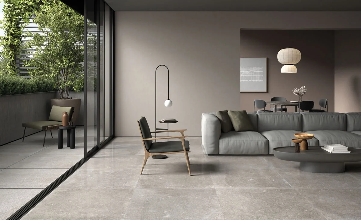 Living space flooring featuring the Evolution collection in Greyge by Kronos Ceramiche, a concrete-look porcelain stoneware designed to bridge indoor and outdoor spaces seamlessly, available through PietraCasa.