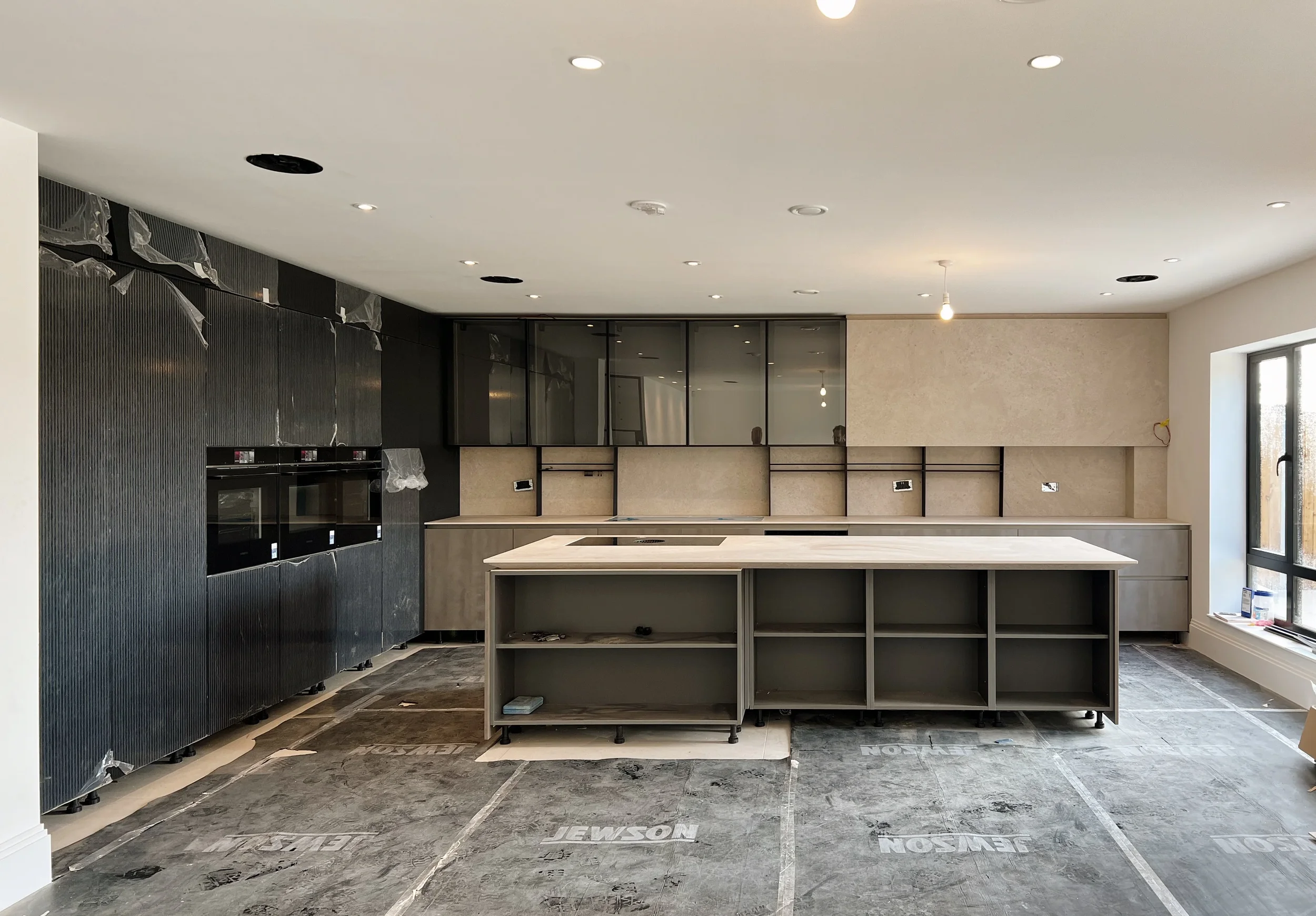 A high-end kitchen renovation featuring bespoke-fabricated porcelain cabinetry and worktops. The design showcases precision joinery and seamless material integration.