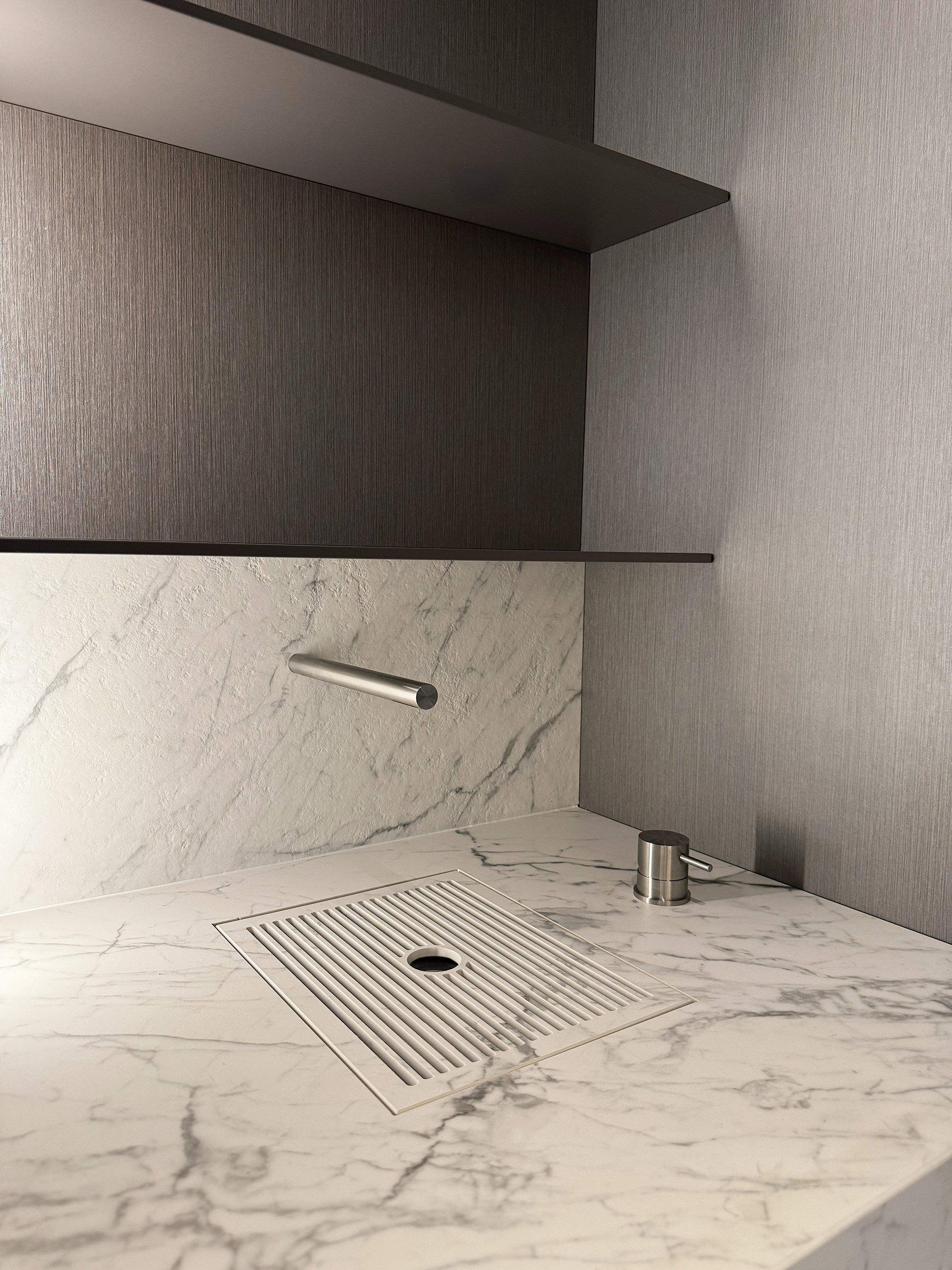 Custom waterjet cut slatted marble drainage grille integrated into a bespoke luxury bar area sink and countertop vanity, fabricated by PietraCasa.