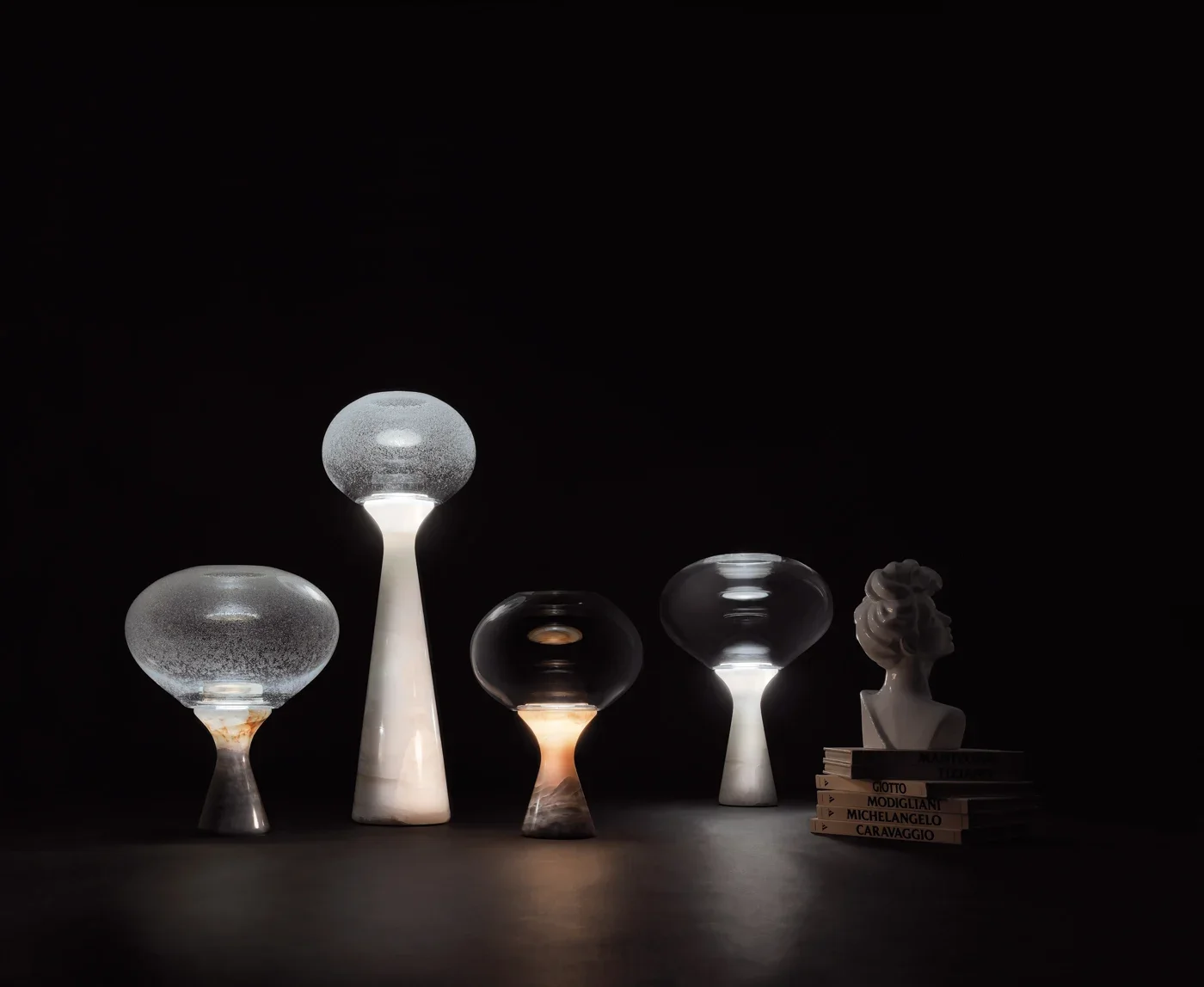 The Magika table lamp collection designed by Enzo Berti for Kreoo, featuring sophisticated combinations of marble and glass, available through PietraCasa.