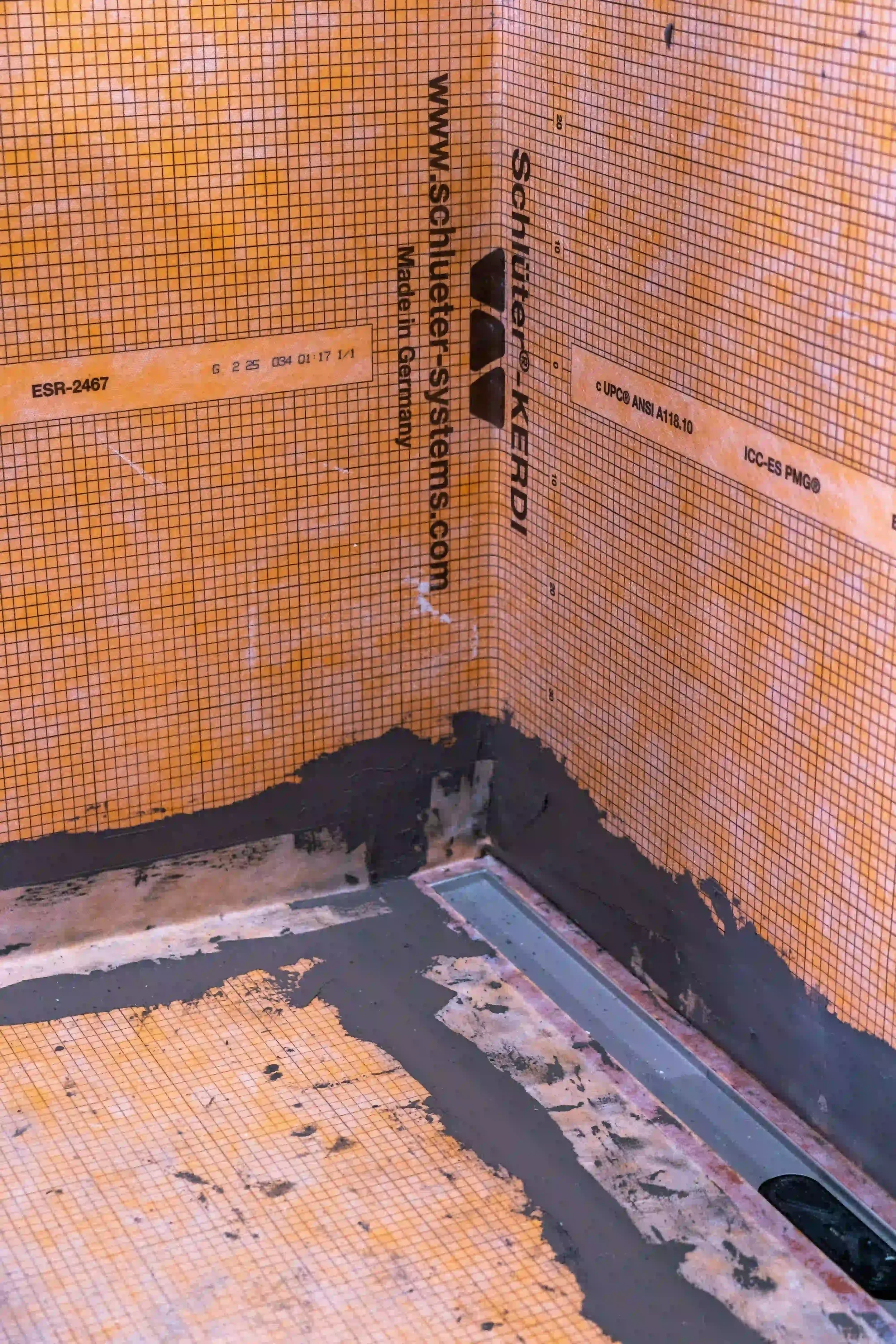 Interior corner installation of Schlüter-KERDI waterproofing membrane featuring a linear drainage channel, prepared for tiling, supplied by PietraCasa.